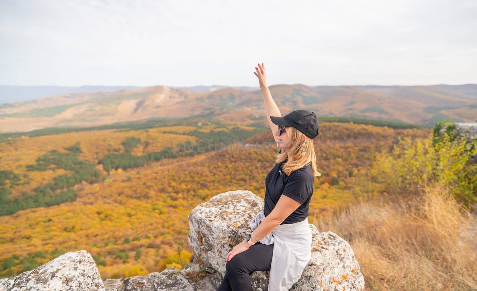 woman on mountain peak looking in beautiful mountain valley in autumn. Landscape with sporty young woman, blu sky in fall. Hiking. Nature by Matiunina