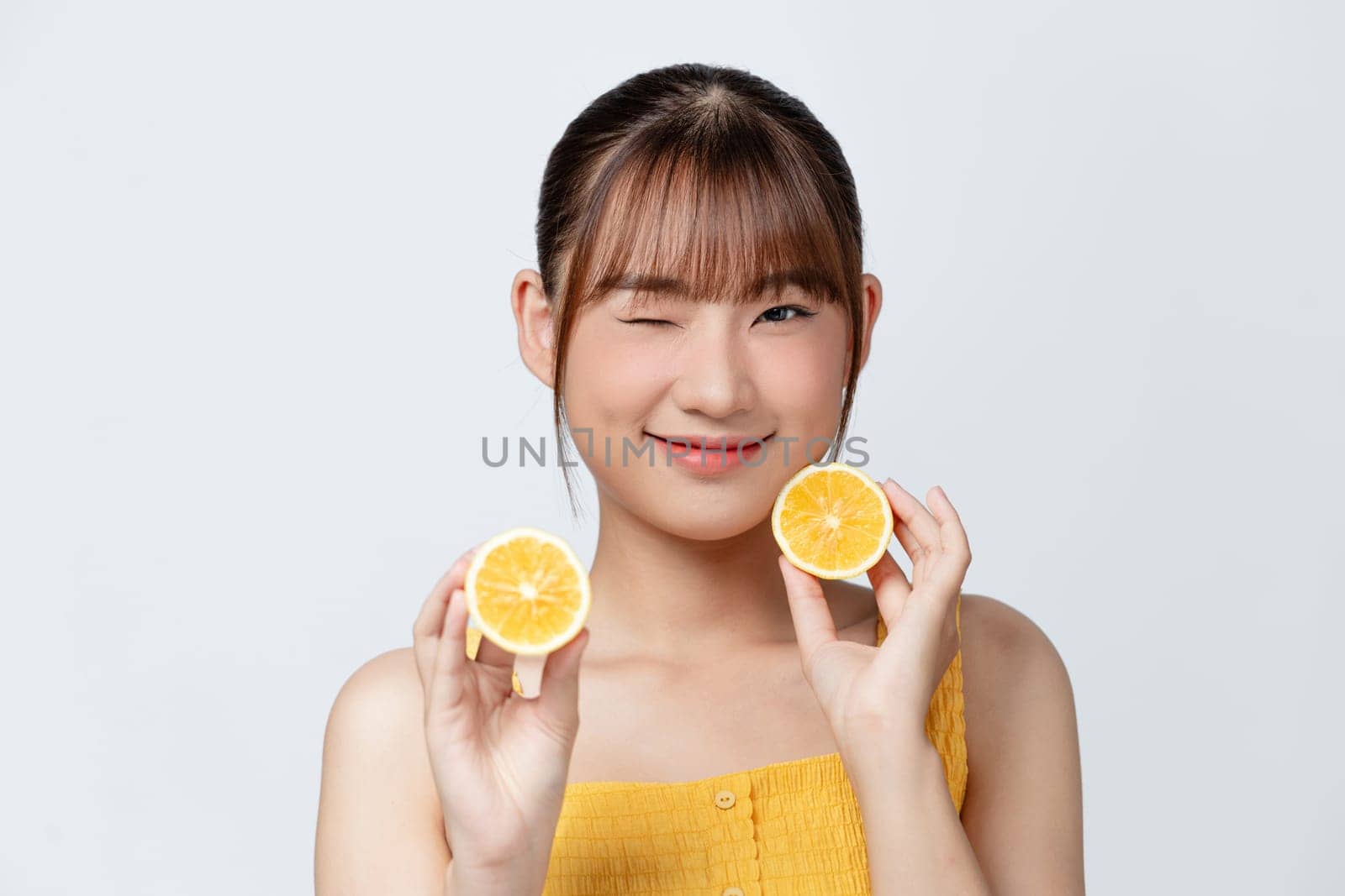 Young beautiful girl with clean perfect skin with lemon close-up. Cosmetics and care for young skin by makidotvn