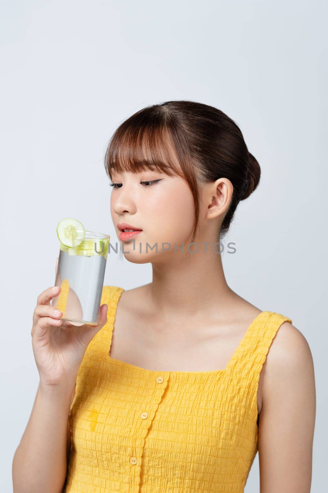 Calm youthful lady refreshing herself with lemon water by makidotvn