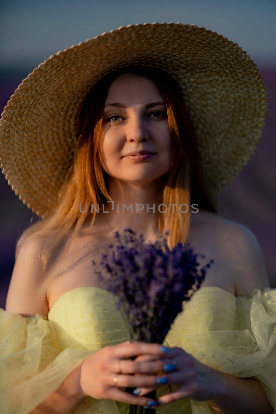 Lavender sunset girl. A laughing girl in a blue dress with flowing hair in a hat walks through a lilac field, holds a bouquet of lavender in her hands. by Matiunina
