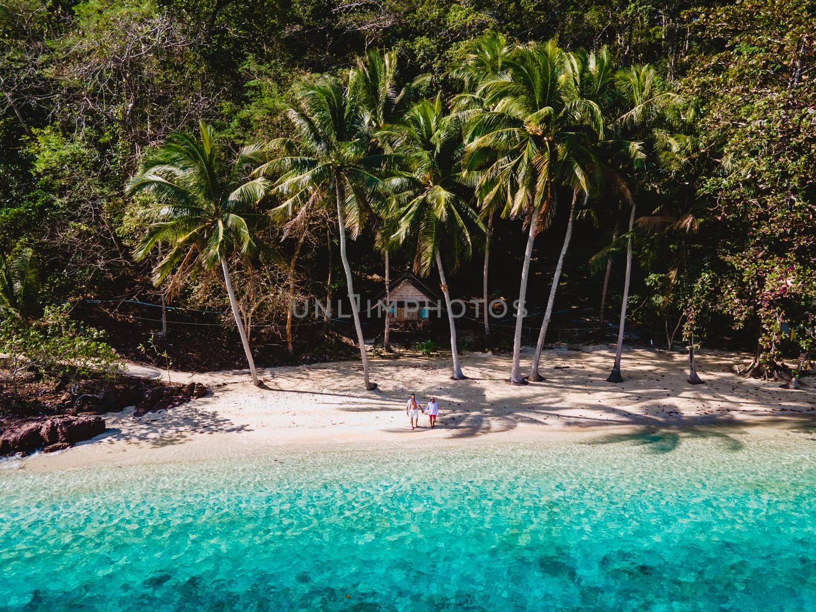 drone view at Koh Wai Island Trat Thailand is a tinny tropical Island near Koh Chang. wooden bamboo hut bungalow on the beach. a young couple of men and woman on a tropical Island in Thailand