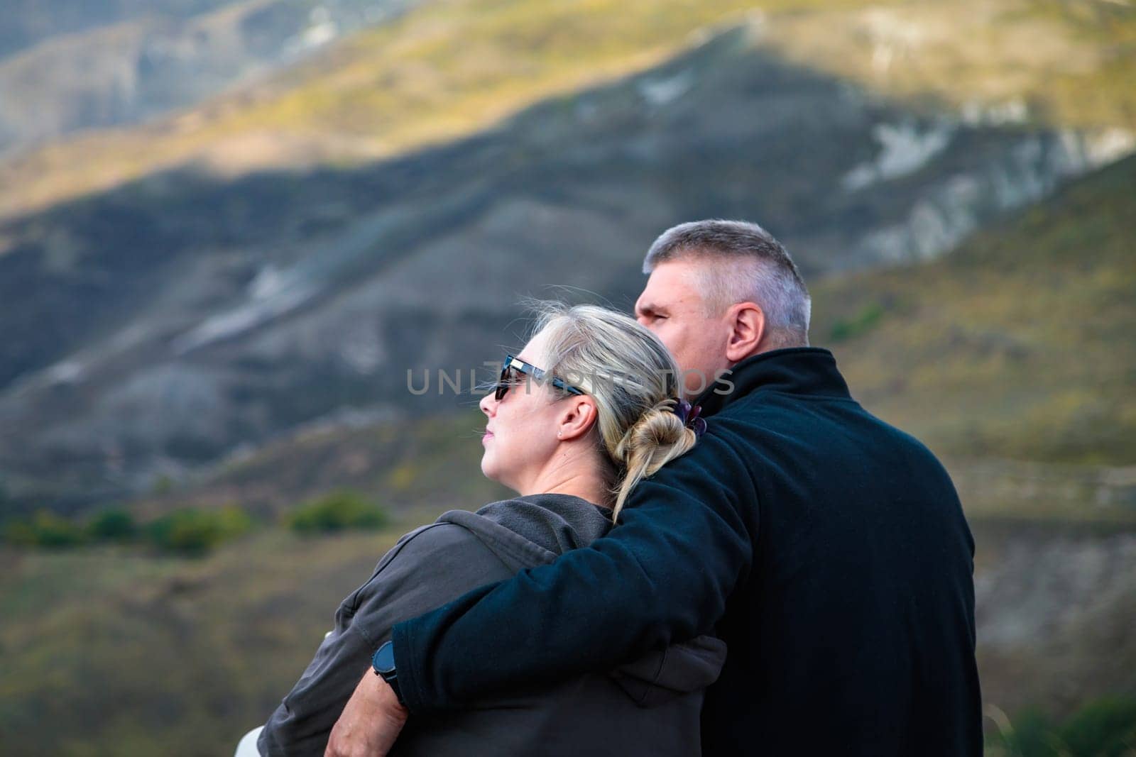 Couple in love with respect near mountain nature, hugging each other