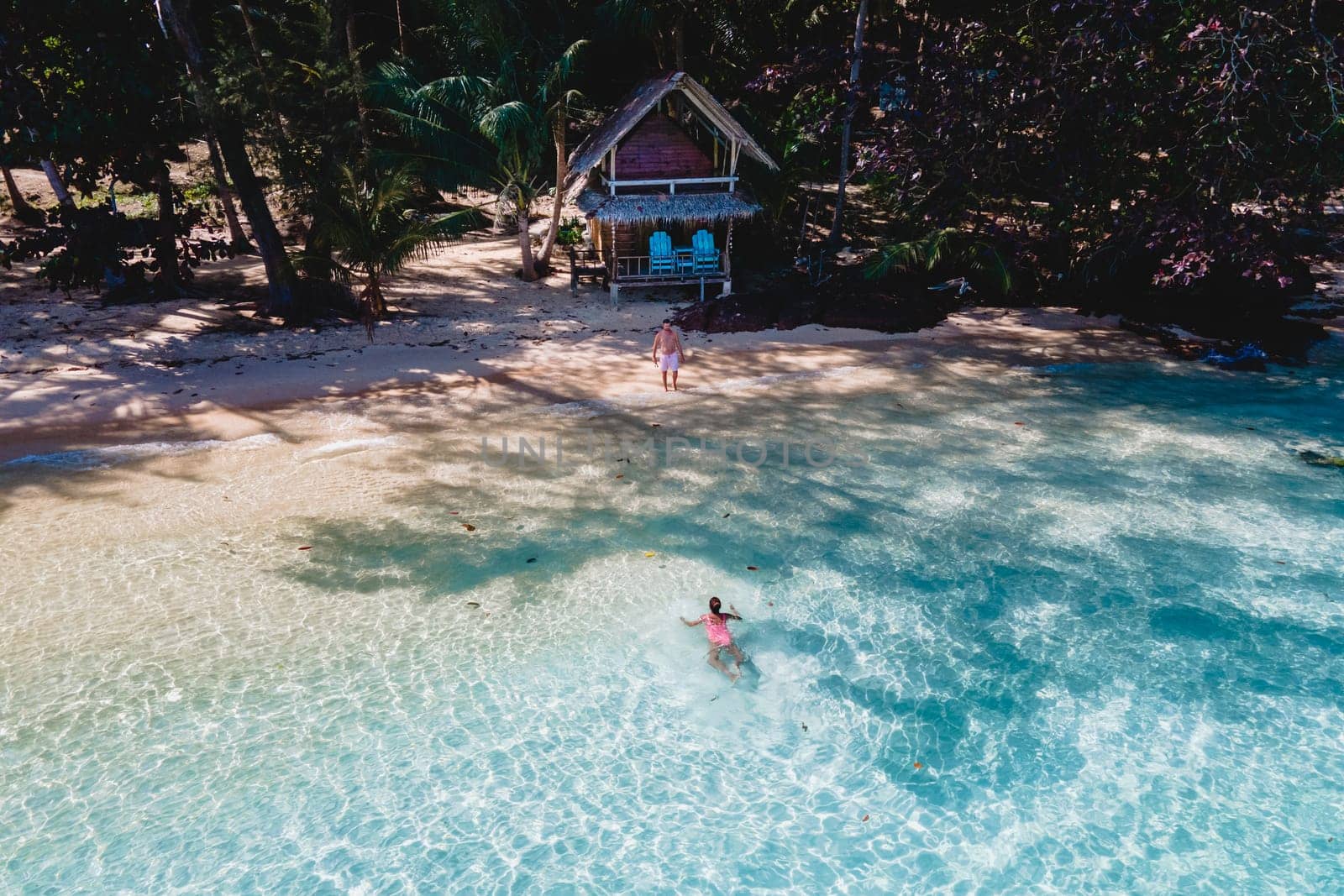 Koh Wai Island Trat Thailand near Koh Chang. wooden bamboo hut bungalow on the beach. a young couple of men and woman on a tropical Island in Thailand swimming in the blue ocean