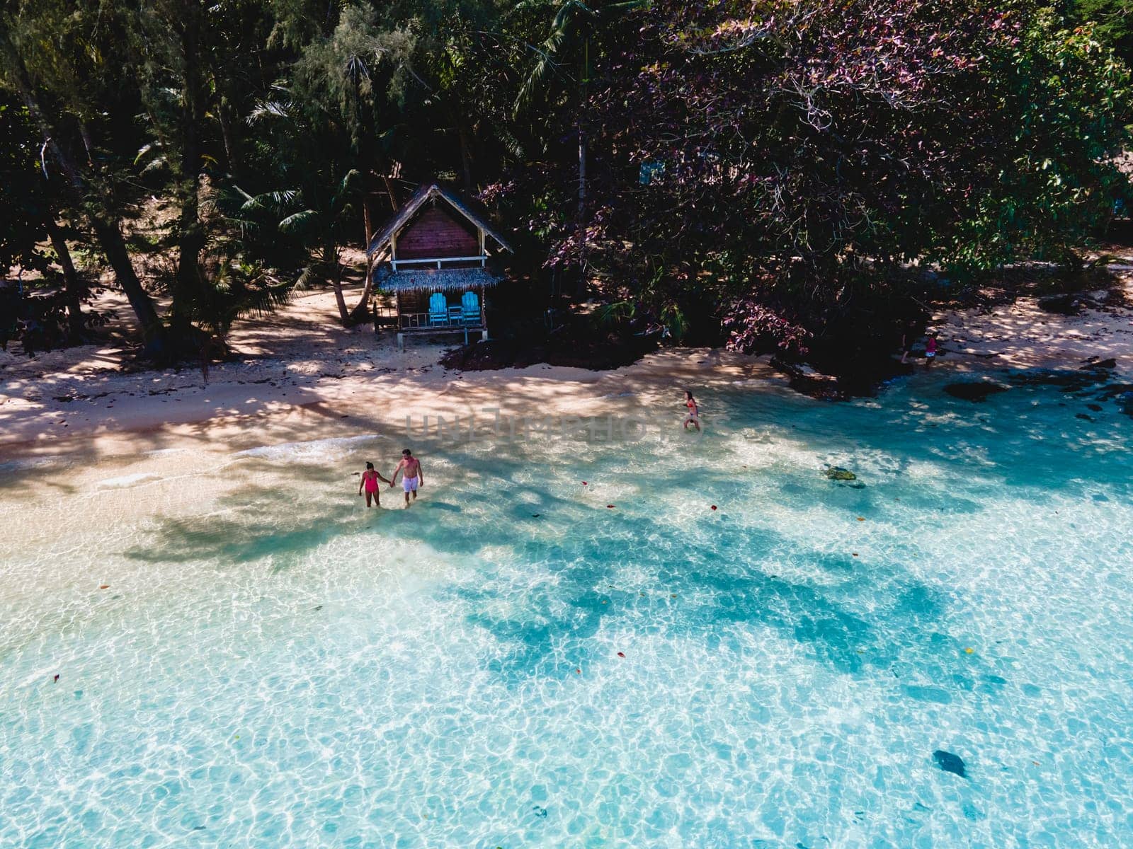 Koh Wai Island Trat Thailand is a tinny tropical Island near Koh Chang. wooden bamboo hut bungalow on the beach. a young couple of men and woman on a tropical Island in Thailand in the blue ocean