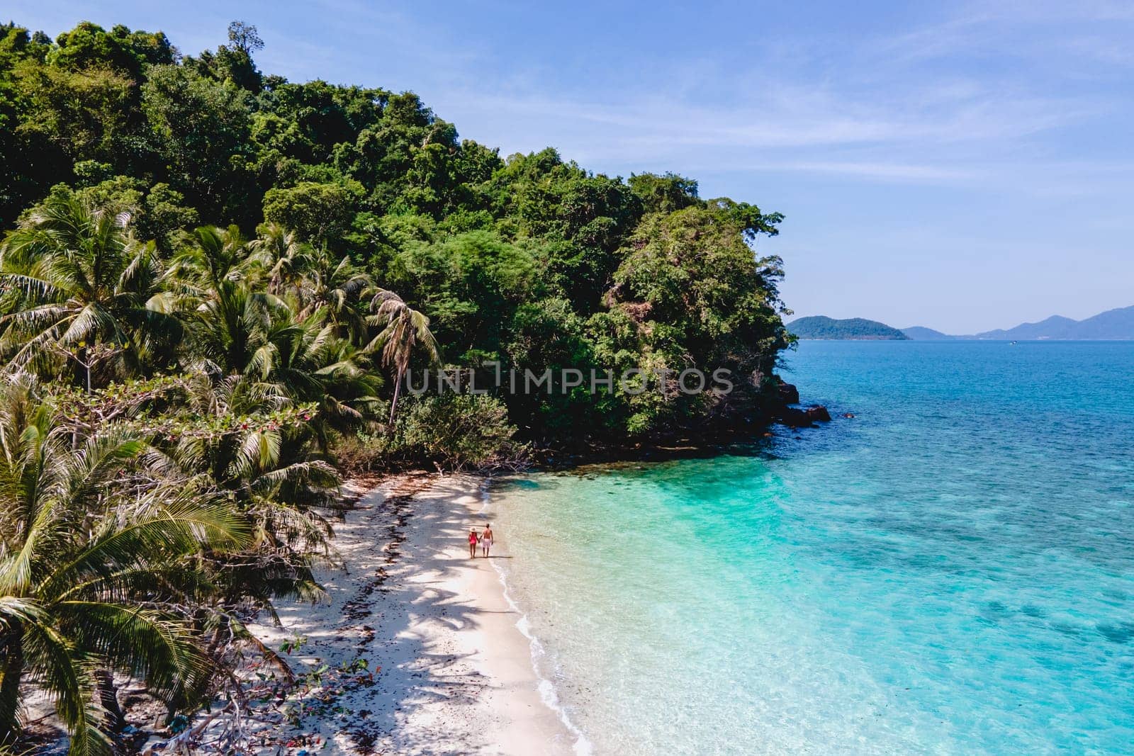 Drone aerial view at Koh Wai Island Trat Thailand . a young couple of men and women walking on a tropical beach during a luxury vacation in Thailand