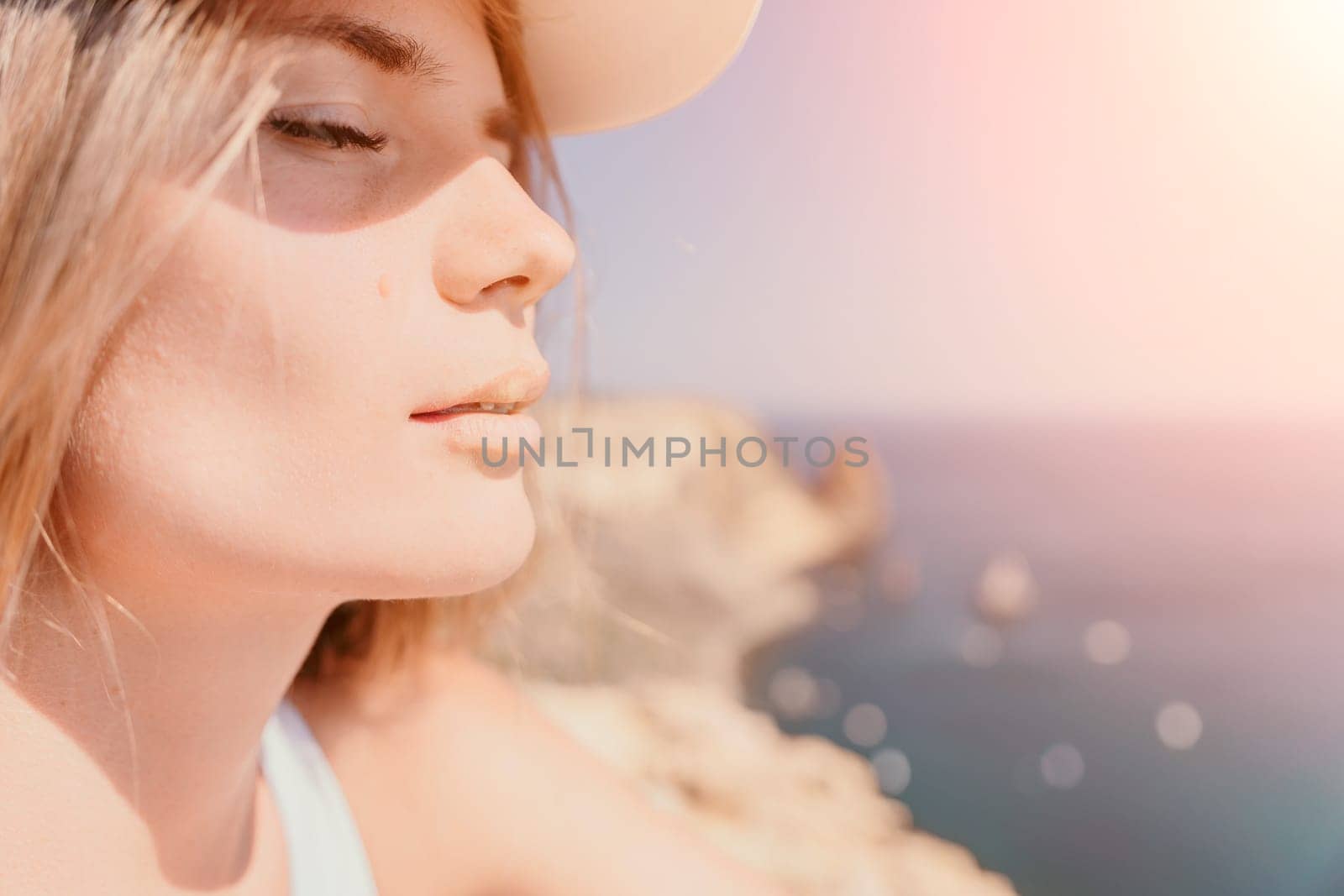 Woman travel sea. Happy tourist in hat enjoy taking picture outdoors for memories. Woman traveler posing on the beach at sea surrounded by volcanic mountains, sharing travel adventure journey by panophotograph