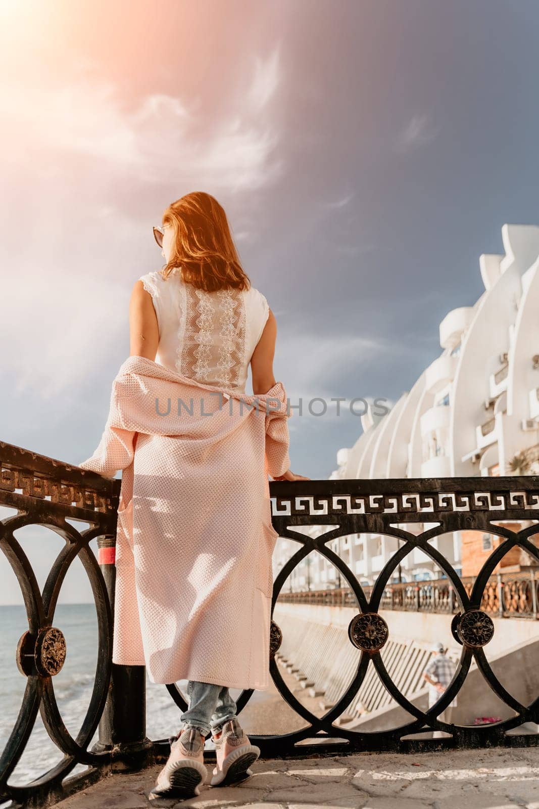 Woman summer travel sea. Happy tourist enjoy taking picture outdoors for memories. Carefree woman traveler posing on beach at sea on sunset, sharing travel adventure journey. Holiday vacation concept. by panophotograph