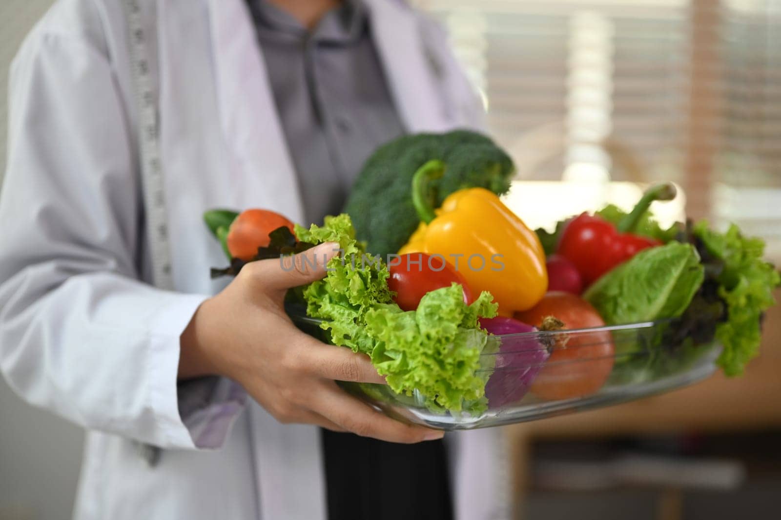 Cropped shot of dietitian holding a bowl of vegetables for healthy eating and diet.