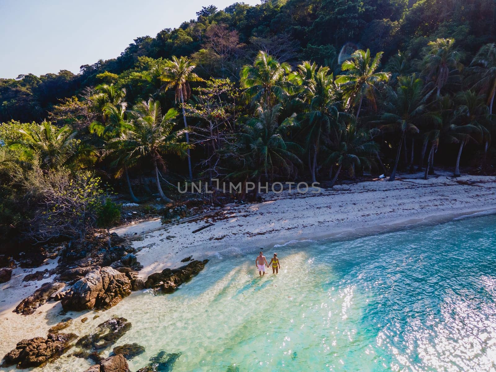 Drone aerial view at Koh Wai Island Trat Thailand is a tinny tropical Island near Koh Chang. a young couple of men and women relaxing on a tropical beach during a luxury vacation in Thailand