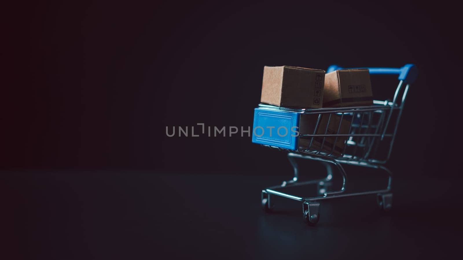 Shopping concept. Paper boxes in blue shopping cart with sale price tag on white background. online shopping consumers can shop from home and delivery service. with copy space. by Unimages2527
