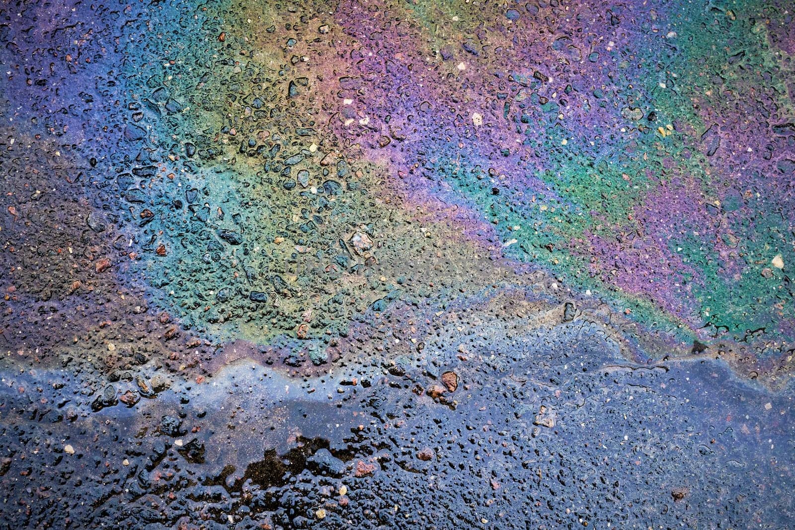 Petrol on the asphalt a big polluted puddle water. A rainbow slick of gasoline