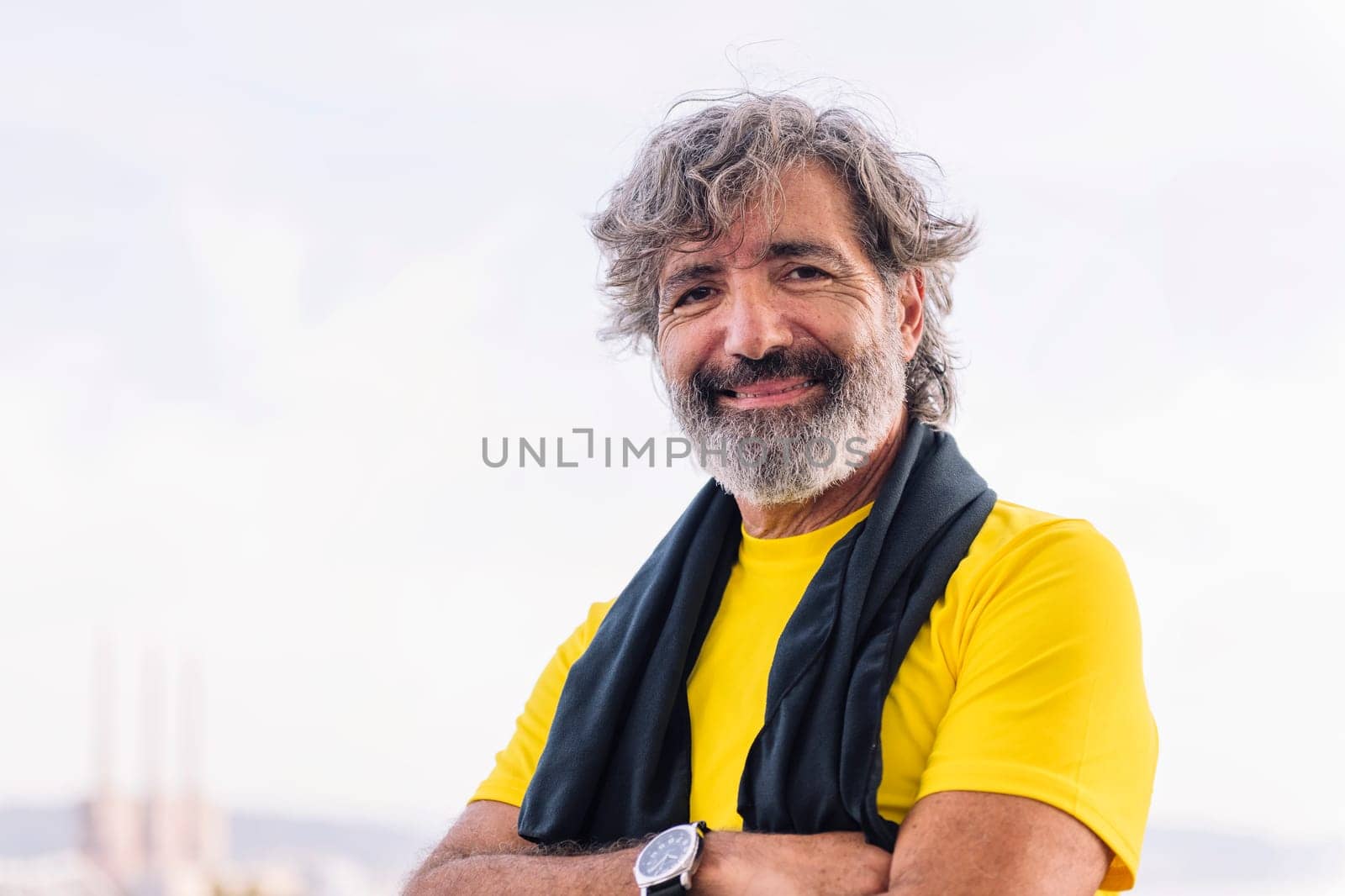 portrait looking at camera of a sporty senior man smiling happy, concept of active and healthy lifestyle in the middle age, copy space for text