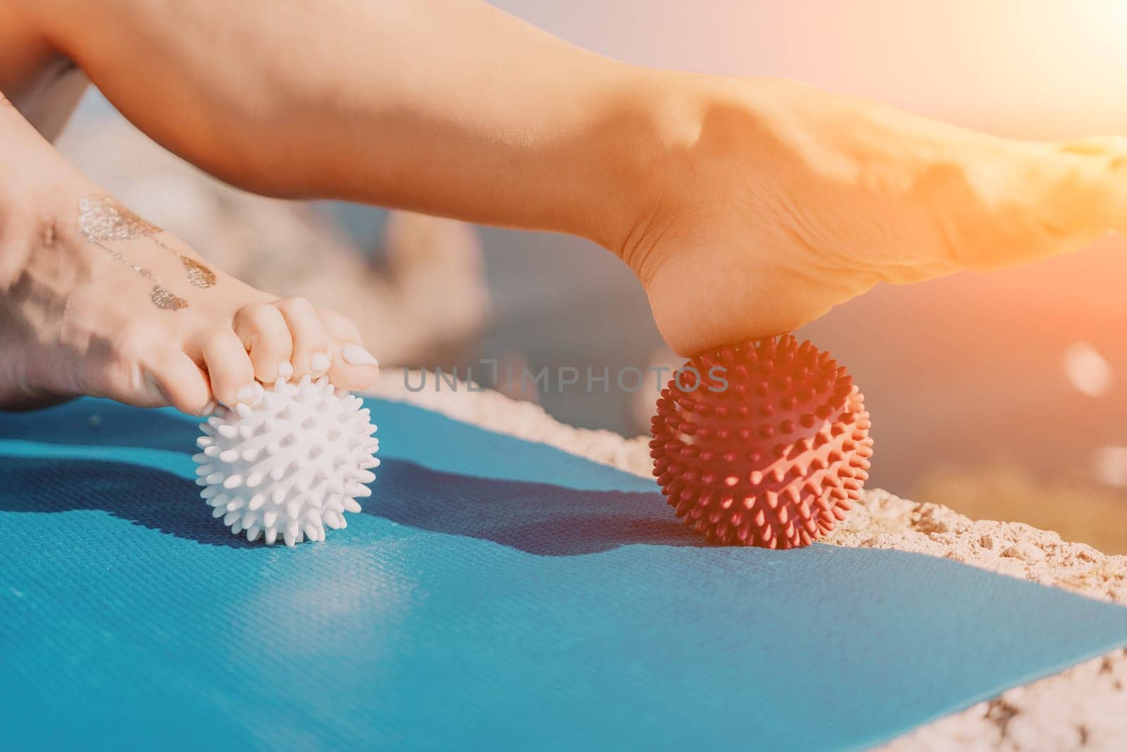 Woman sea pilates. Sporty happy middle aged woman practices pilates on yoga mat by the sea, using massage balls and roller near sea, smiling active female outside, enjoying healthy lifestyle by panophotograph