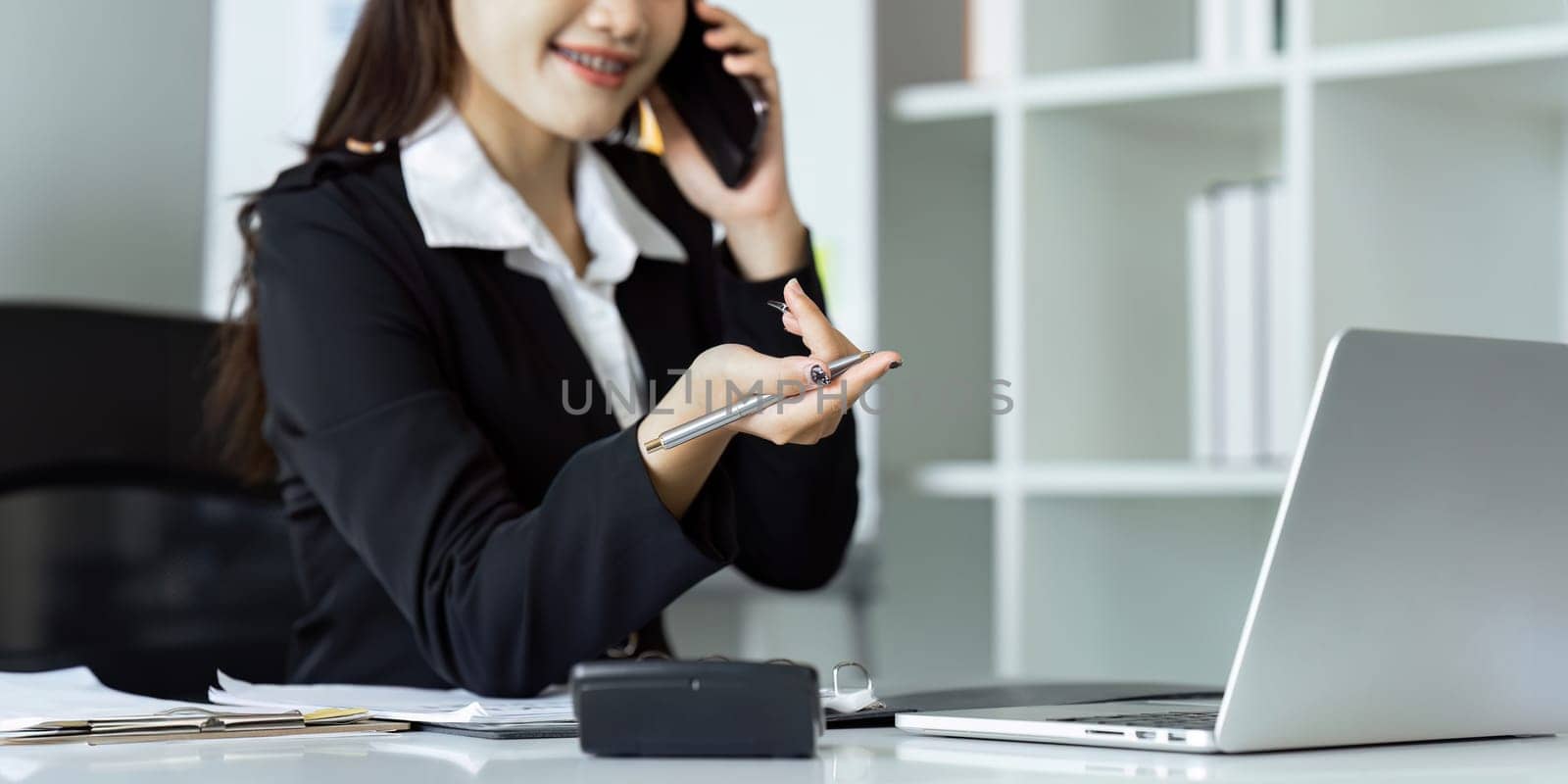 Businesswoman on the phone and using laptop at office. Businesswoman professional talking on mobile phone by itchaznong