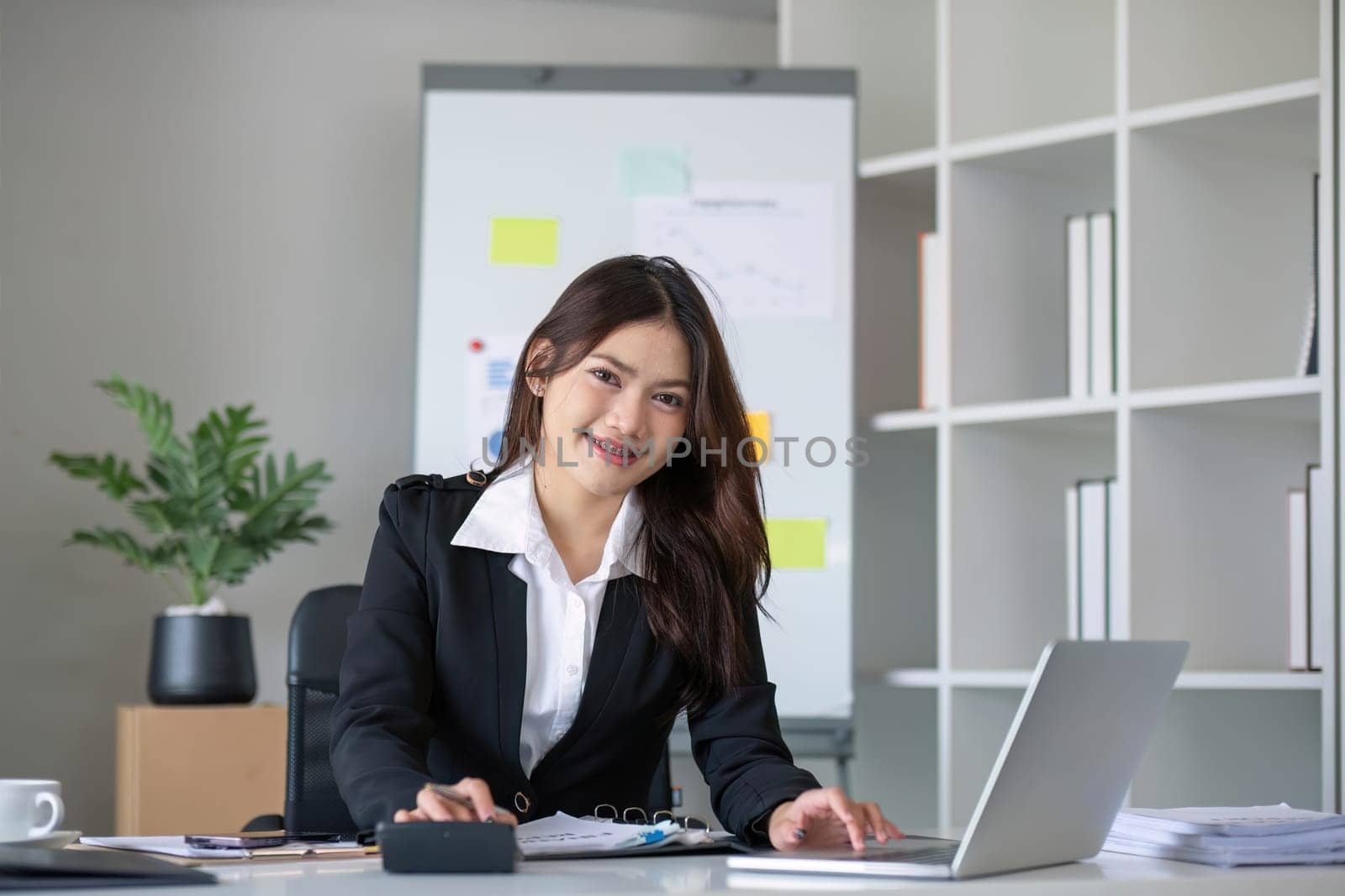 Business woman using calculator for do math finance on wooden desk in office and business working background, tax, accounting, statistics and analytic research concept..