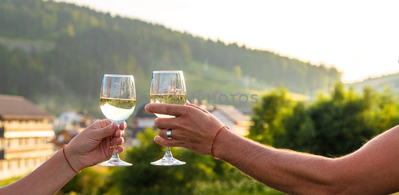 A woman drinks wine against the backdrop of mountains. Selective focus. by yanadjana