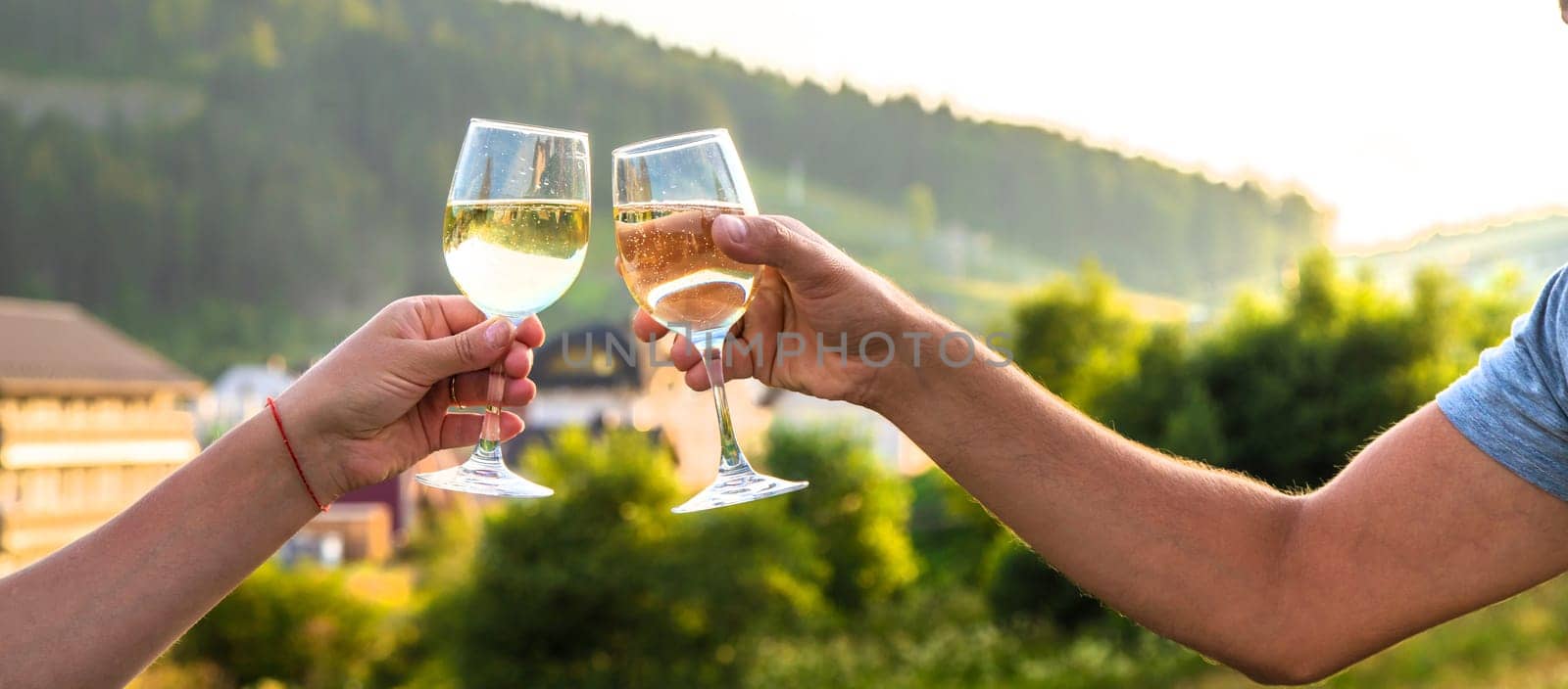 A woman drinks wine against the backdrop of mountains. Selective focus. by yanadjana