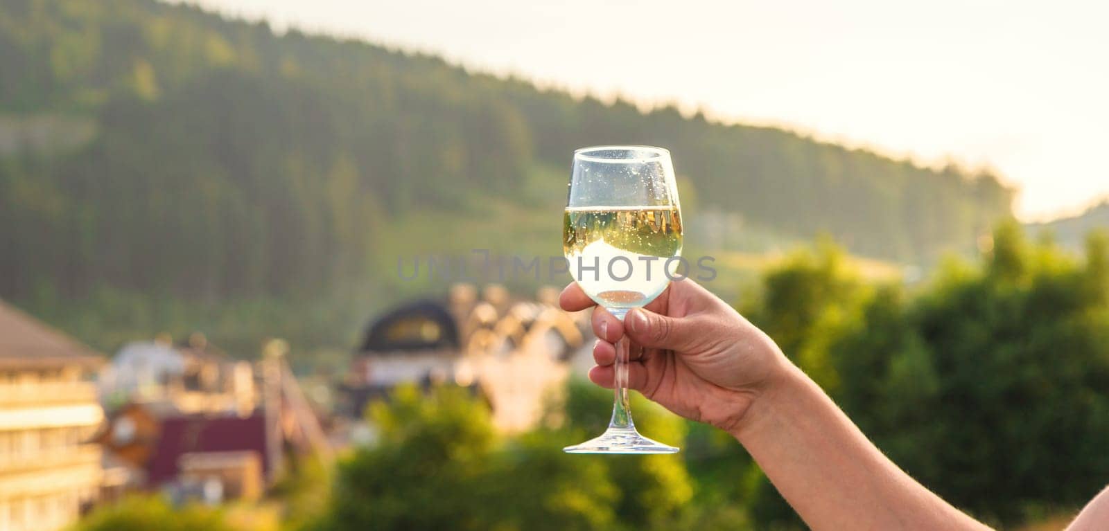 A woman drinks wine against the backdrop of mountains. Selective focus. by yanadjana