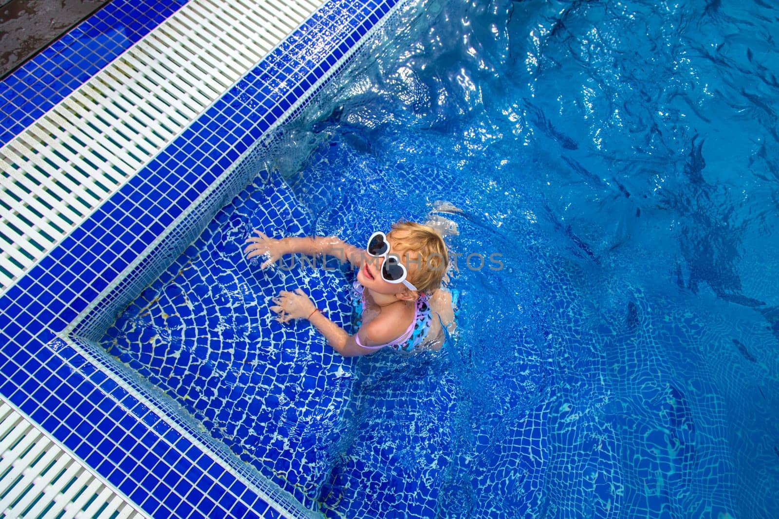 A child swims in the pool. Selective focus. by yanadjana