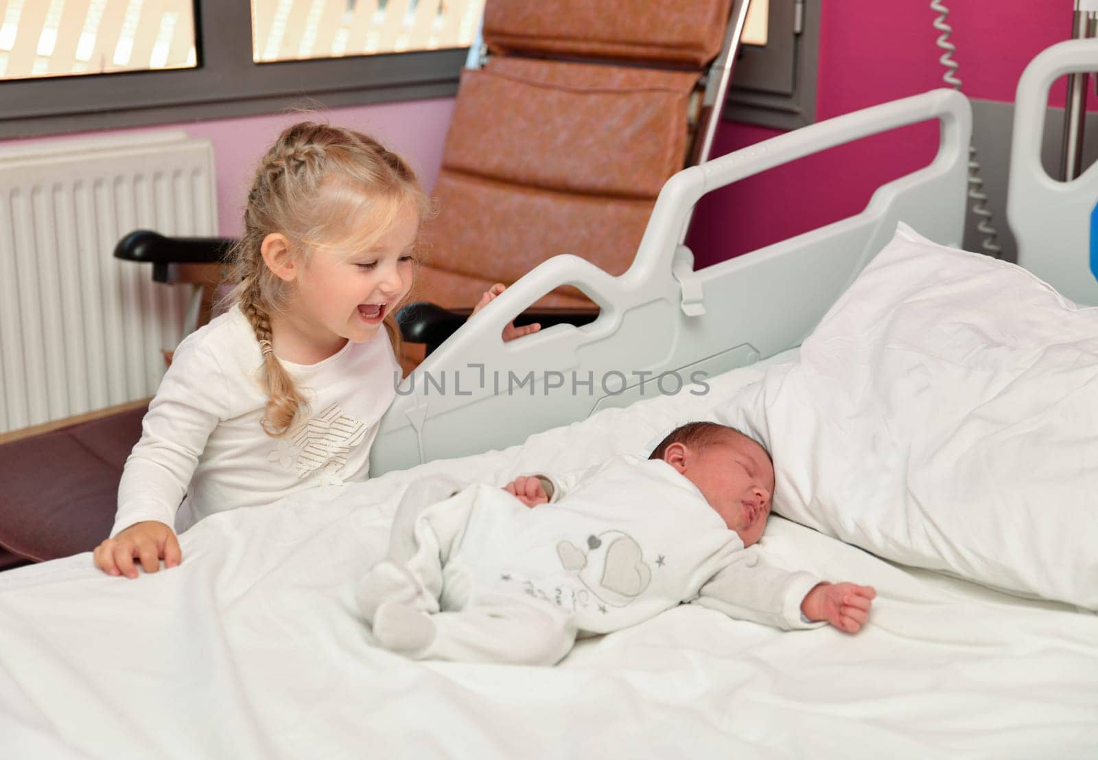 The first acquaintance between a sister and a newborn baby in the hospital ward