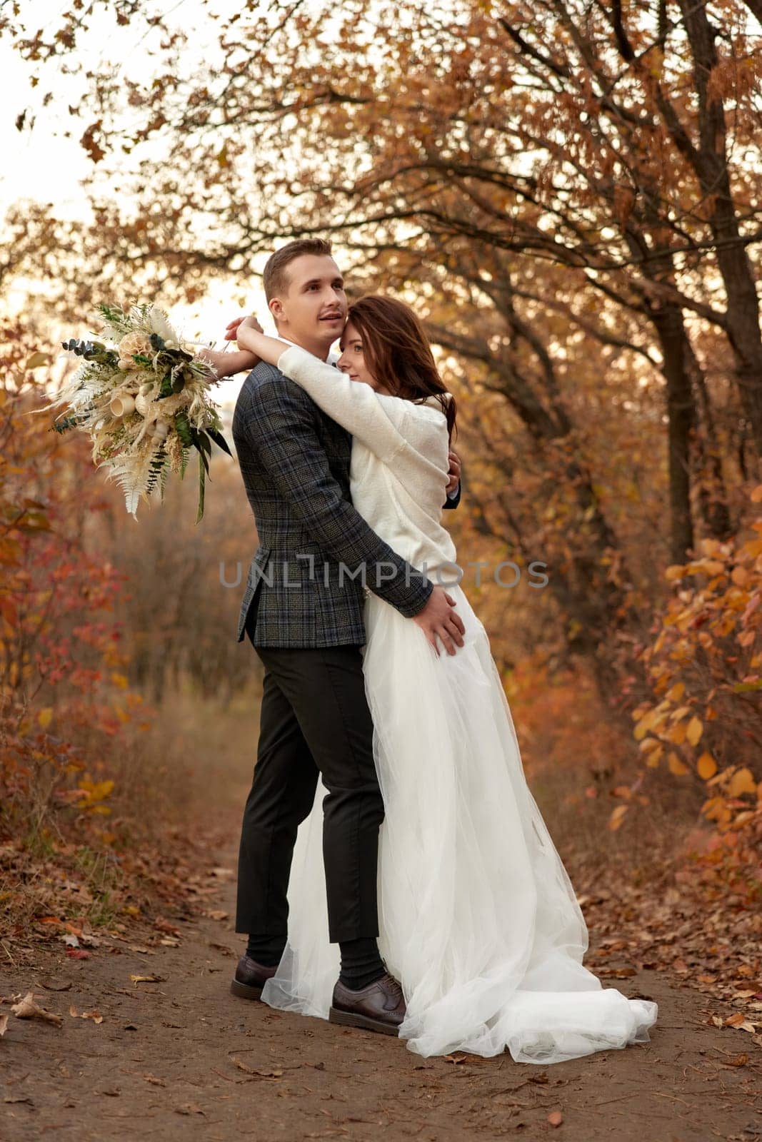 Full length body portrait of bride and groom standing outdoor on natural background