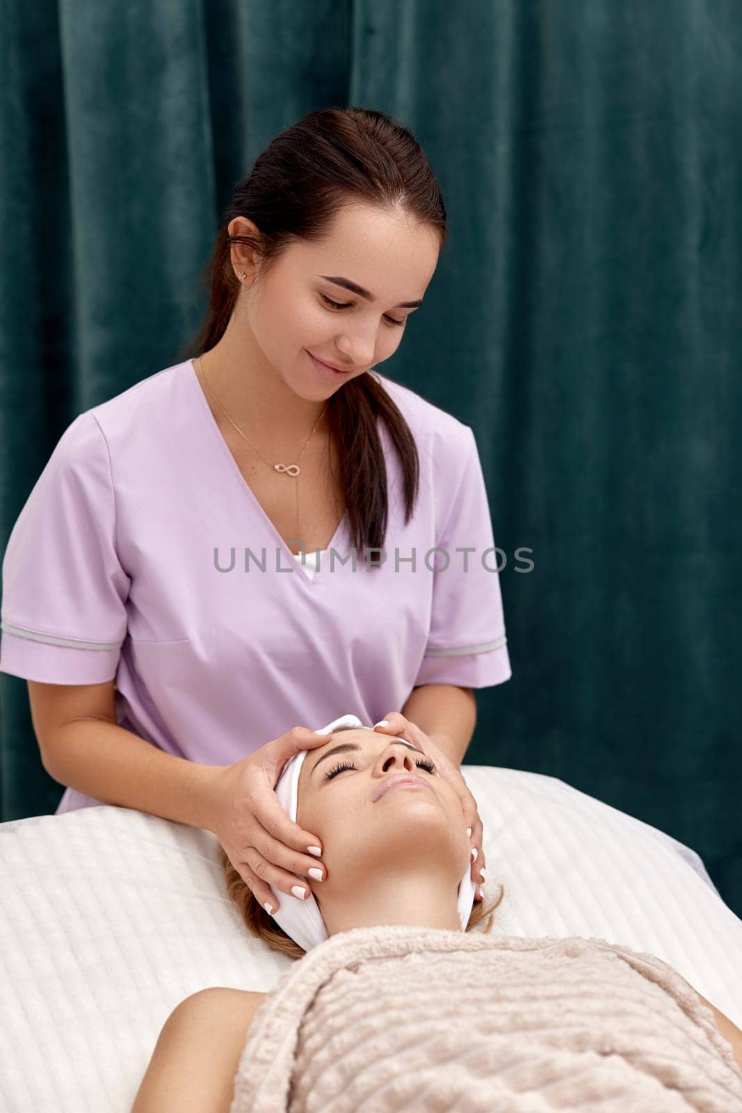 woman getting face massage treatment in beauty salon. by erstudio