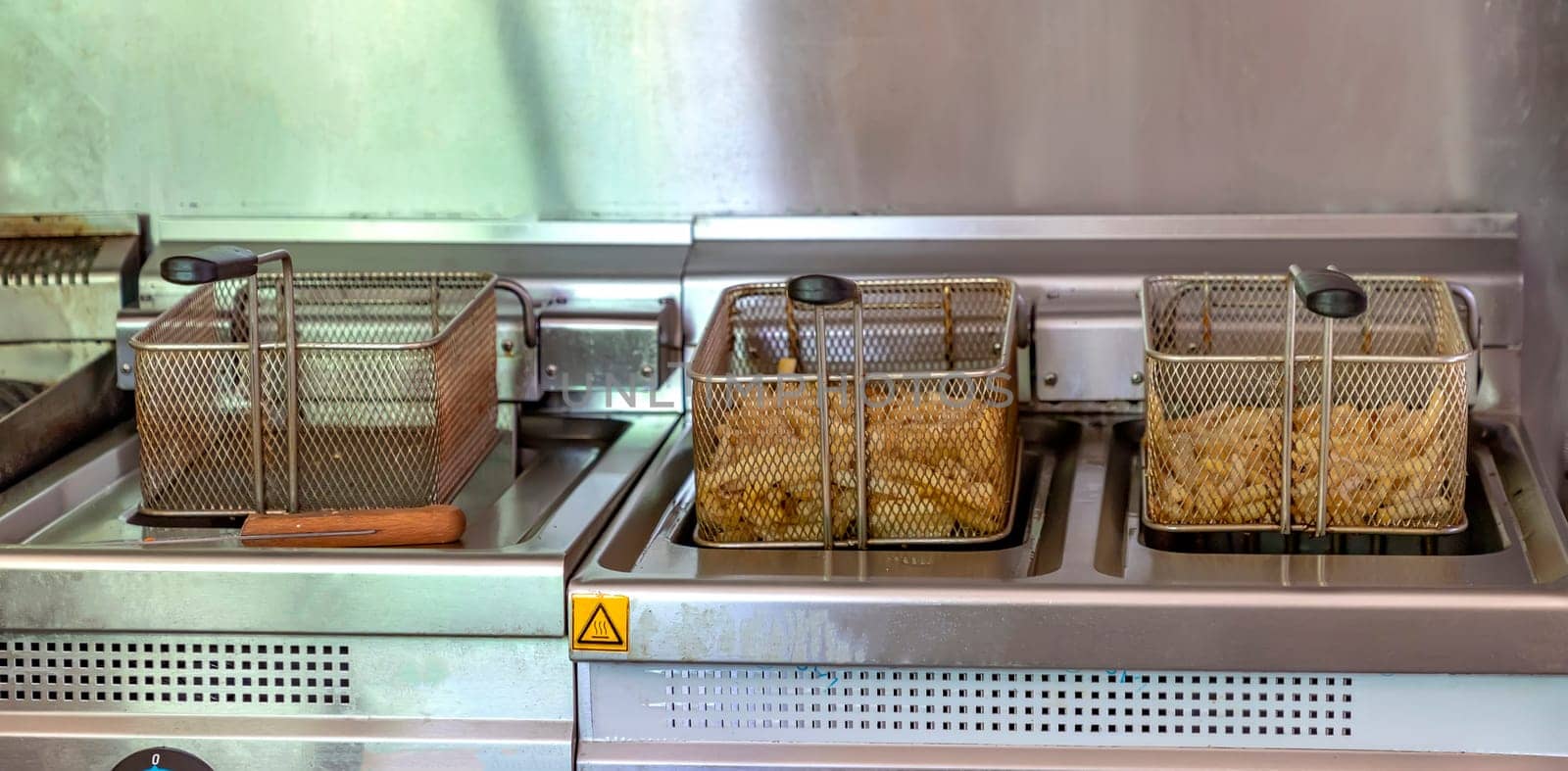 Ready potatoes for frying at the potato fryer. Fast food restaurant concept, kitchen equipment