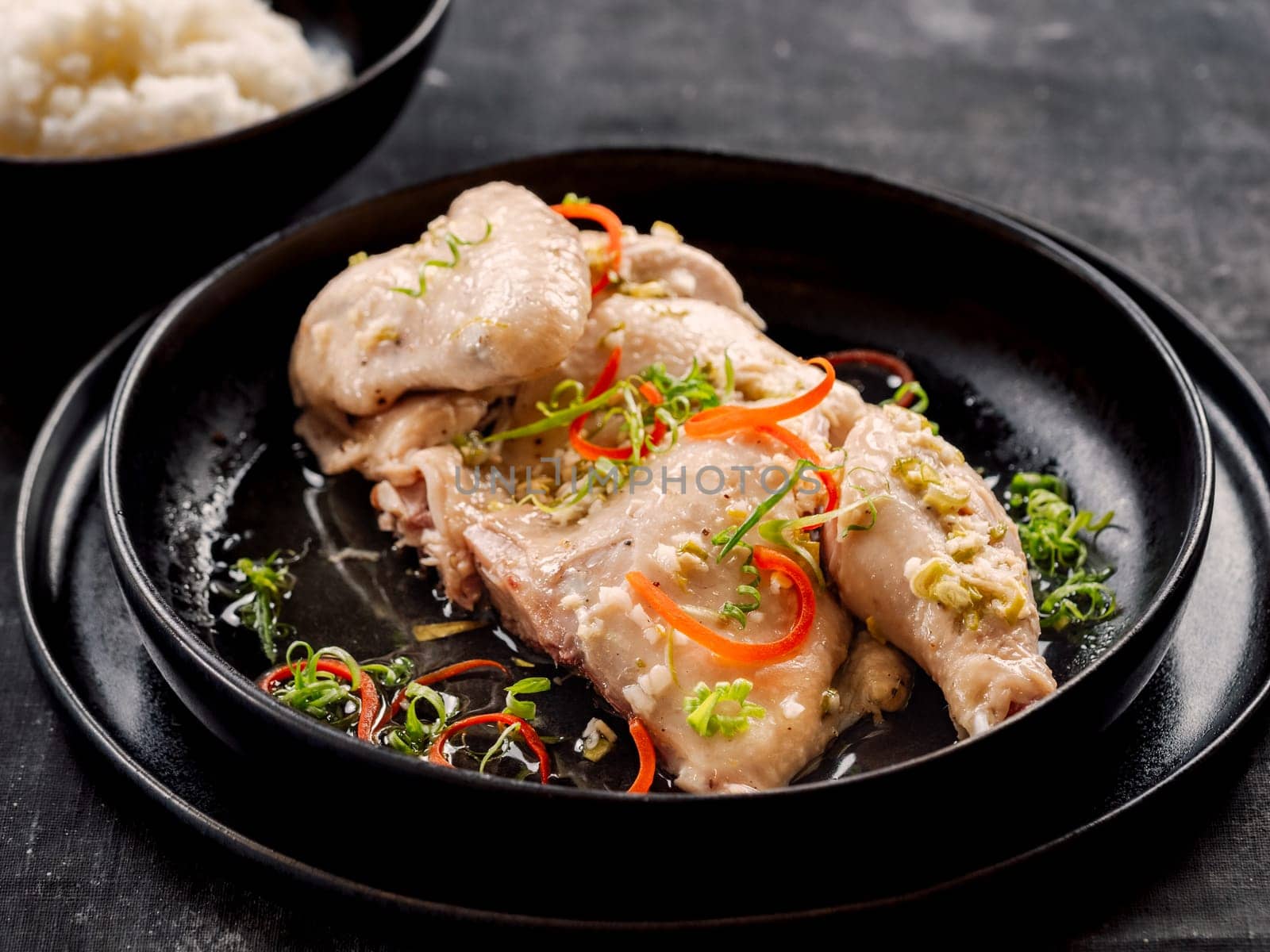 Sous Vide Chicken with spices. Boiled chicken sous-vide on black plate. Sous-vide is culinary method of long-term cooking