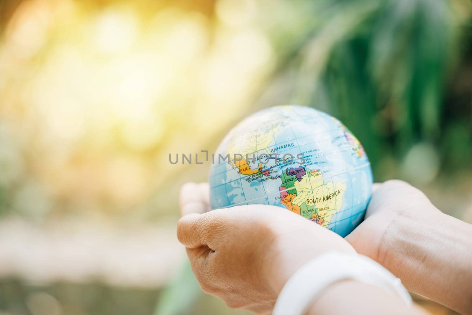 On Environment and Earth Day, hold the Green Planet to signify Earth's preservation. This concept highlights responsibility, wisdom, and global support for our natural world. by Sorapop
