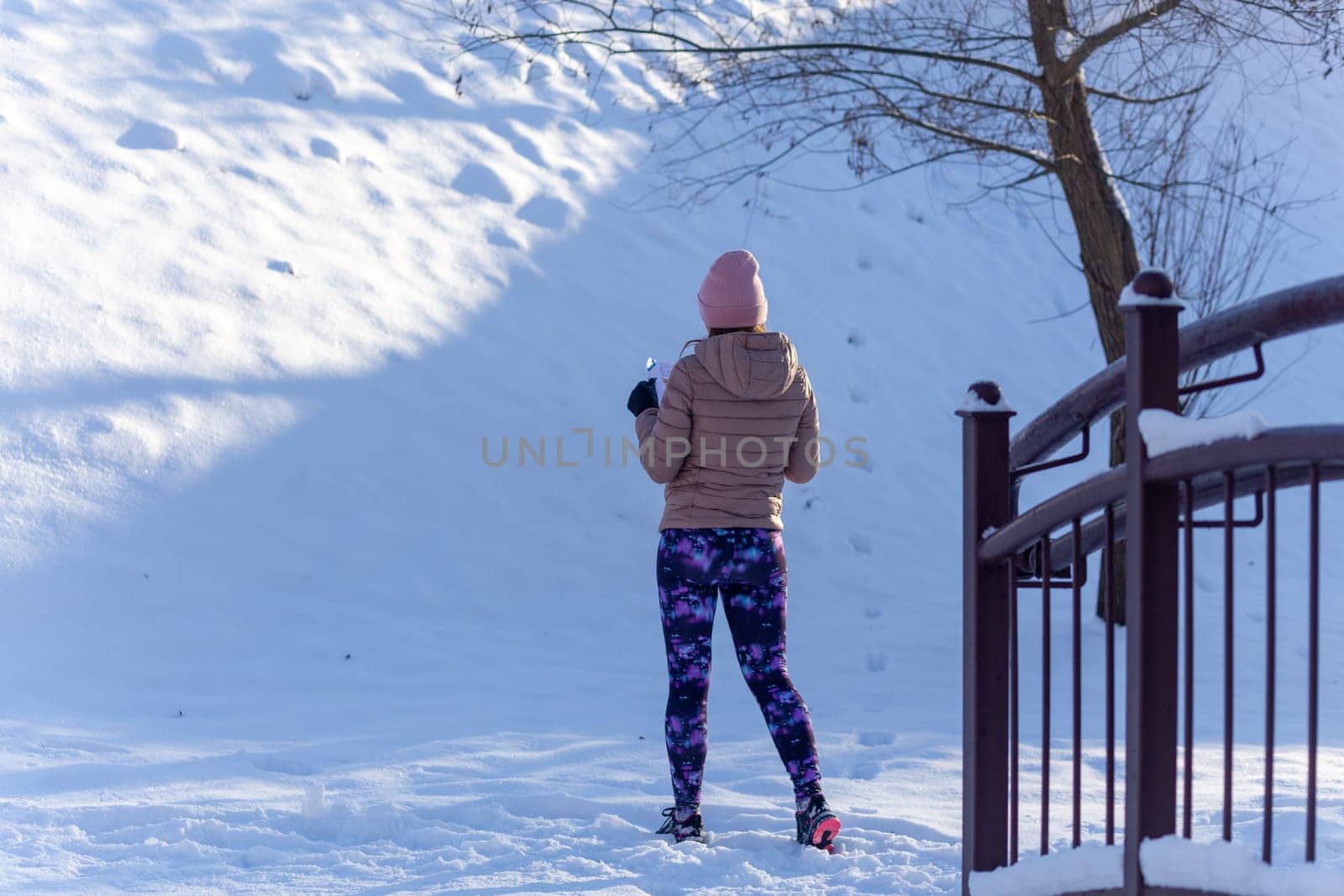 Young woman participates in winter orienteering training in urban conditions. Outdoor orienteering check point activity