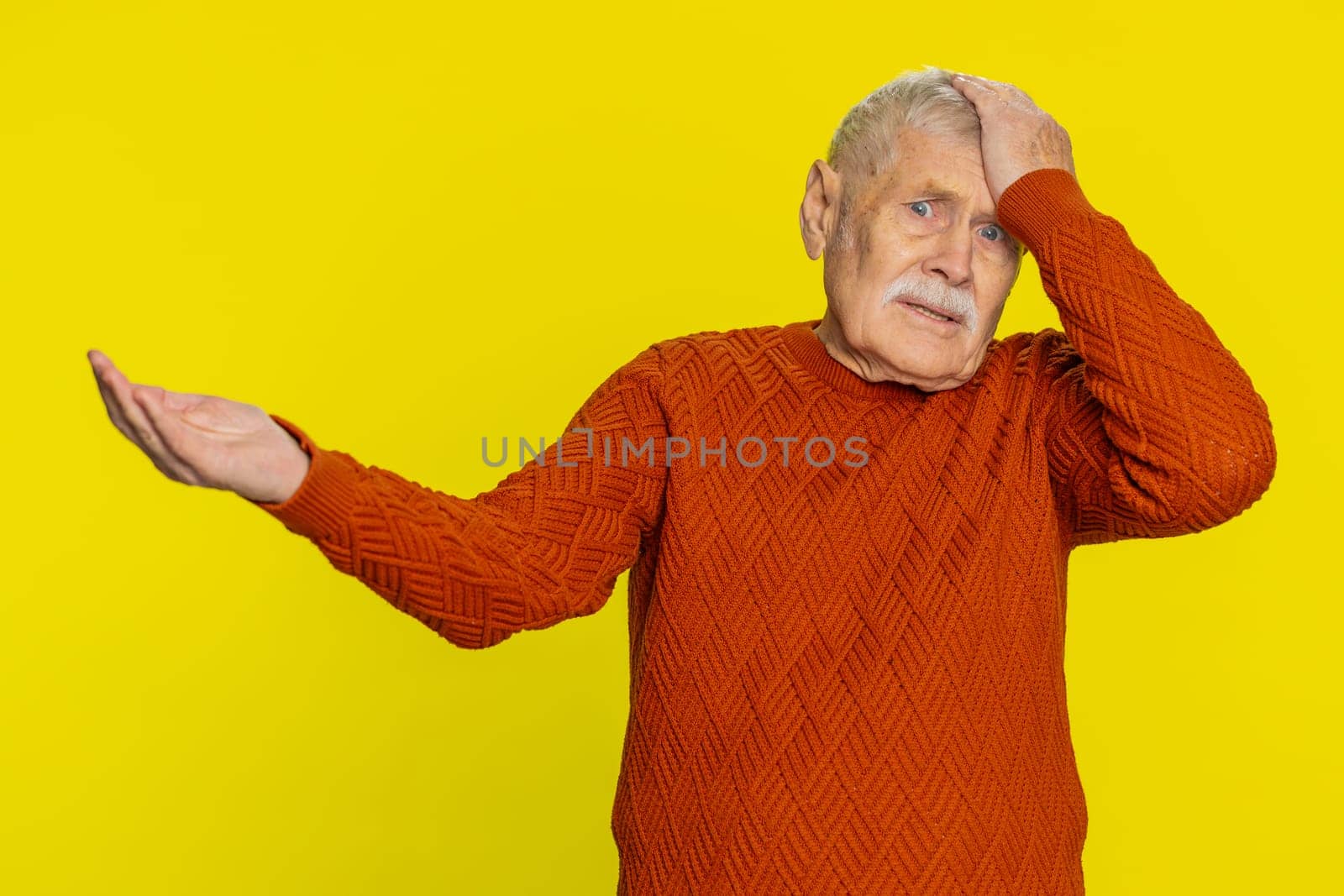 Sad senior old man feeling hopelessness loneliness, nervous breakdown, loses becoming surprised by lottery results, bad fortune, loss unlucky news. Mature grandfather isolated on yellow background