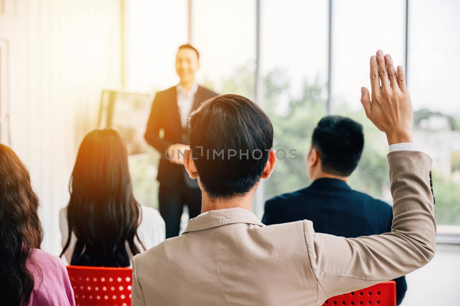 Audience engagement at a conference as hands are raised for questions, emphasizing the interactive nature of the meeting. A diverse group collaborates at a workshop or seminar presentation. by Sorapop