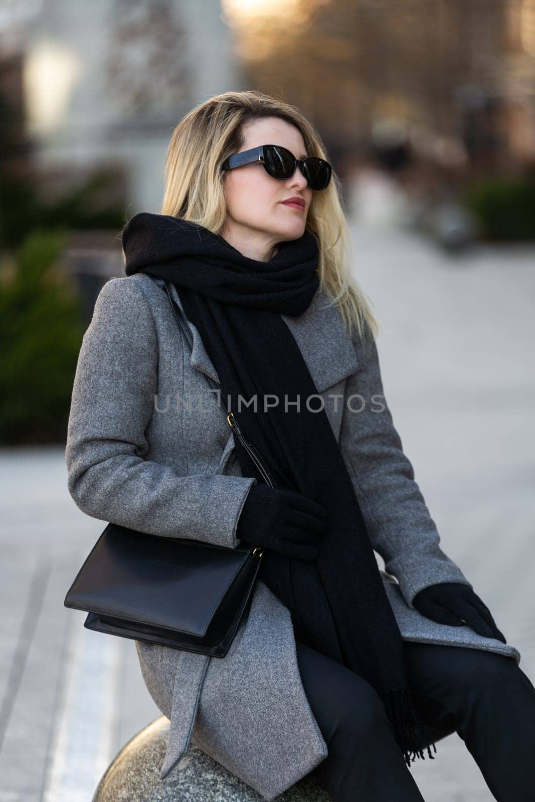 Beautiful girl in a coat and scarf and black glasses. High quality photo