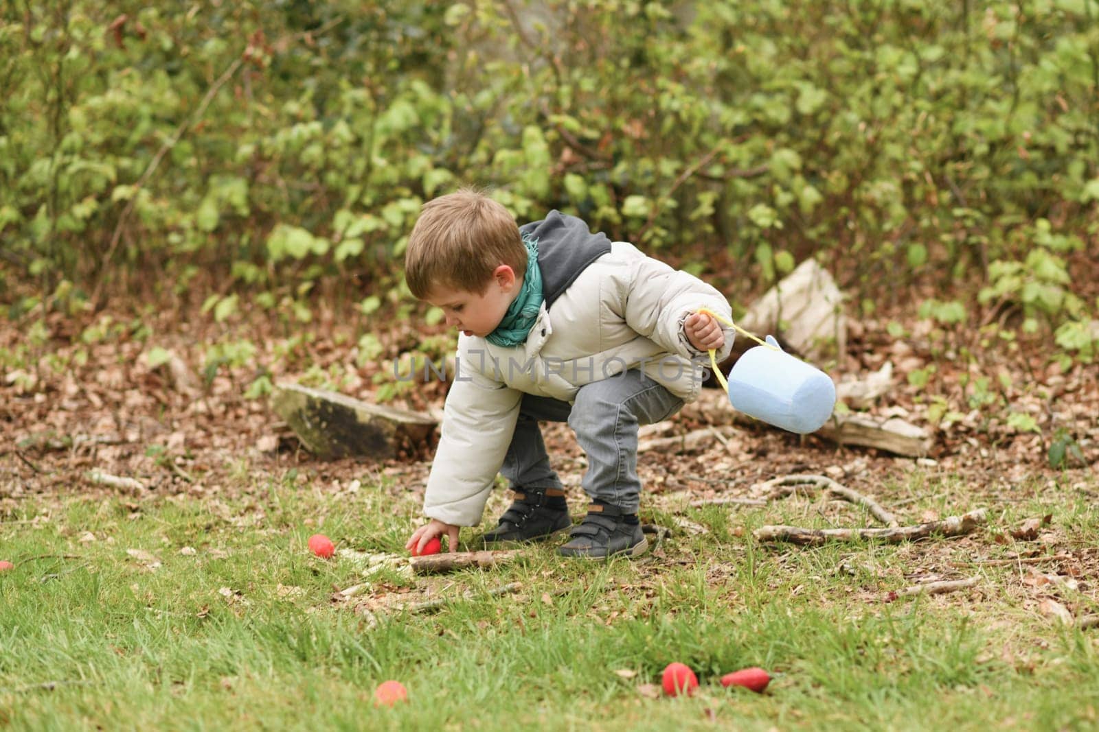 Boy collects the eggs in a basket Easter