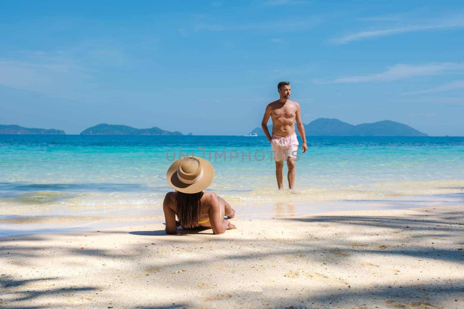 Koh Wai Island Trat Thailand near Koh Chang Trat. A young couple of men and women on a tropical beach during a luxury vacation in Thailand relaxing on the beach with turqouse colored ocean
