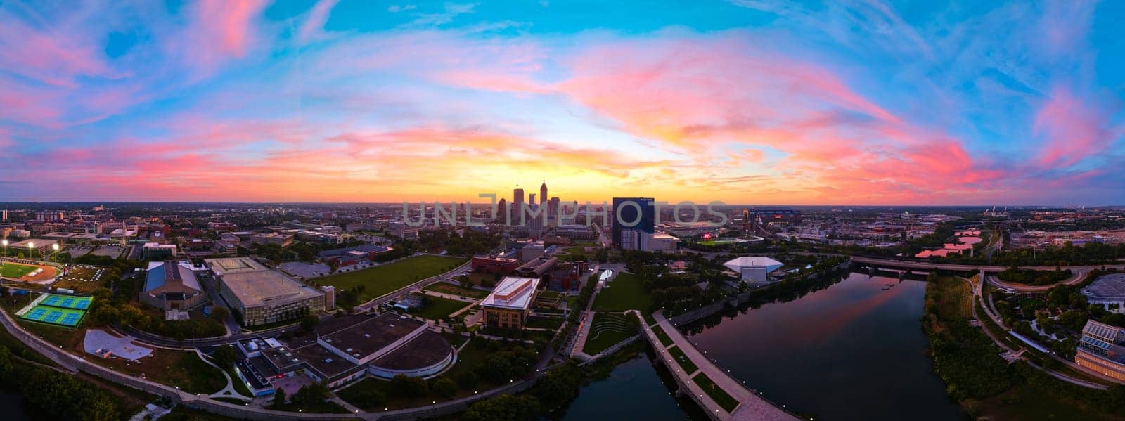 Stunning 2023 aerial panorama of Indianapolis downtown skyline at sunrise, captured by DJI Mavic 3 drone, highlighting the golden hour transitioning to a vibrant pink sky