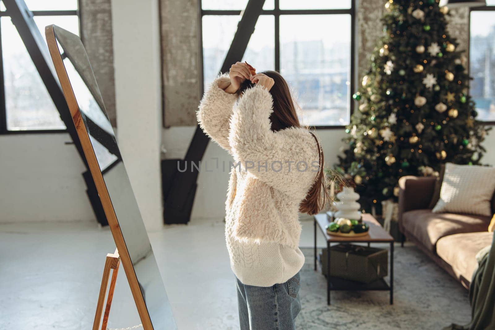 In a joyful moment, a lively young woman wearing a Christmas reindeer mask smiles brightly at home. by teksomolika