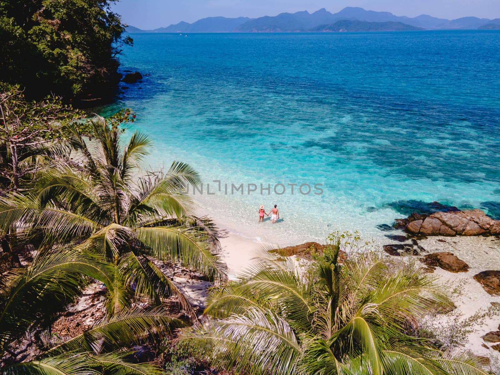 Drone aerial view at Koh Wai Island Trat Thailand a tinny tropical Island near Koh Chang. a young couple of men and women on a tropical beach during a luxury vacation in Thailand