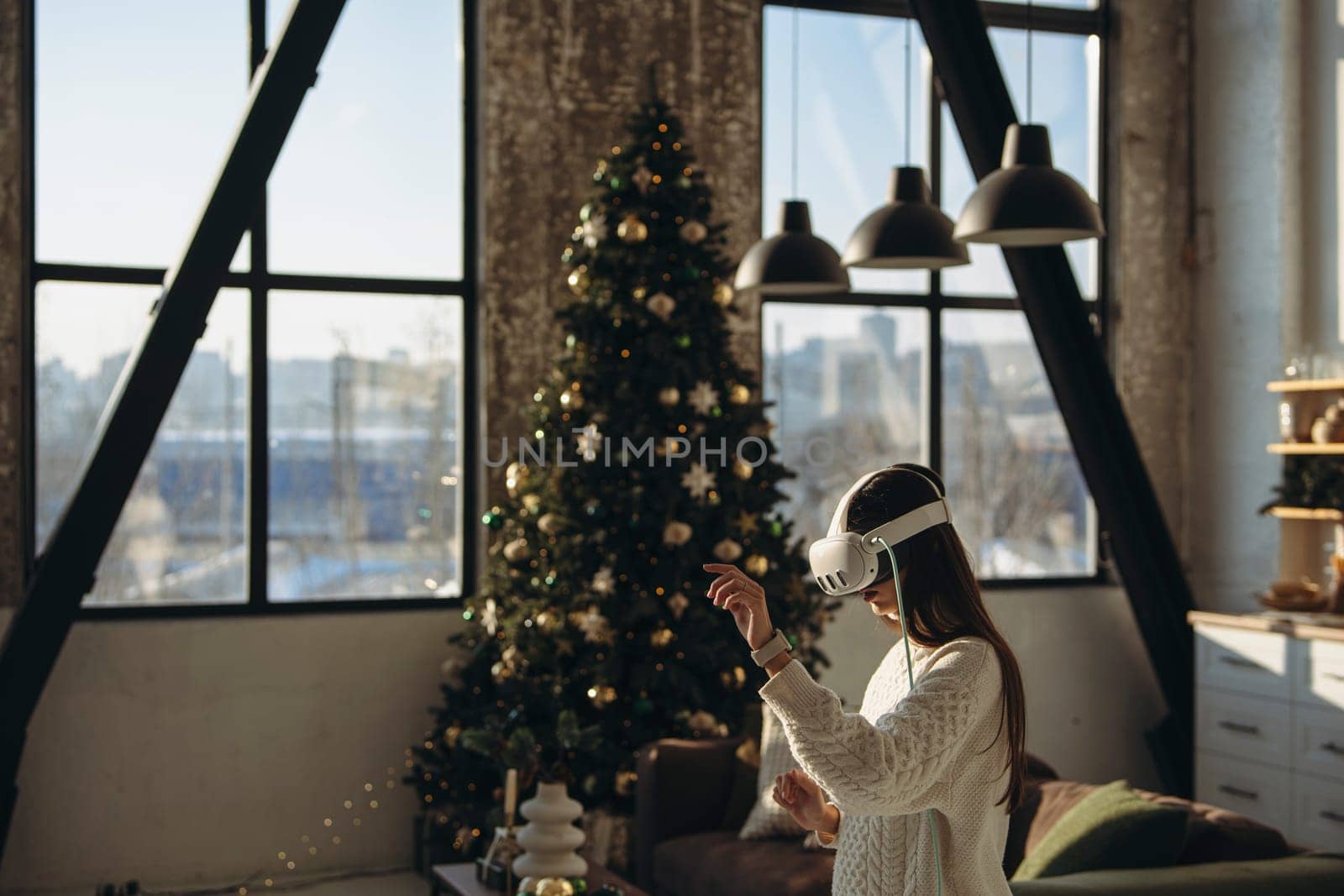 In her apartment, a beautiful young lady enjoys gaming online with a virtual reality headset. High quality photo