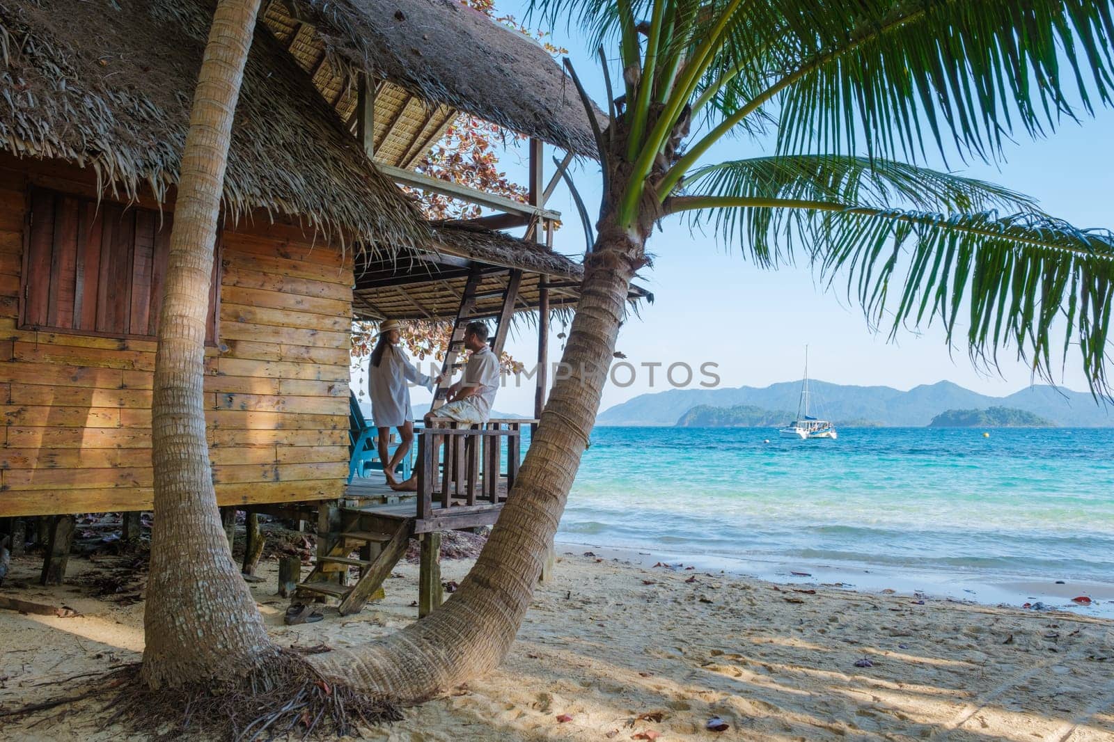 Koh Wai Island Trat Thailand wooden bamboo hut bungalow on the beach. a young couple of men and woman on a tropical Island in Thailand relaxing in a wooden bungalow on the beach