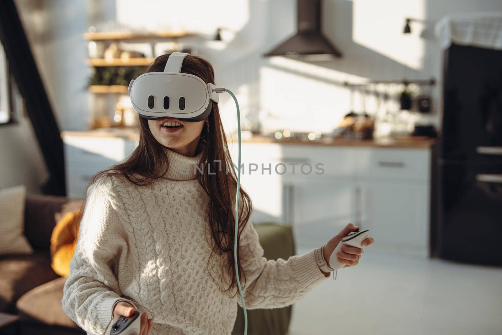 In a sunny ambiance, a lively young girl uses a virtual reality headset. by teksomolika