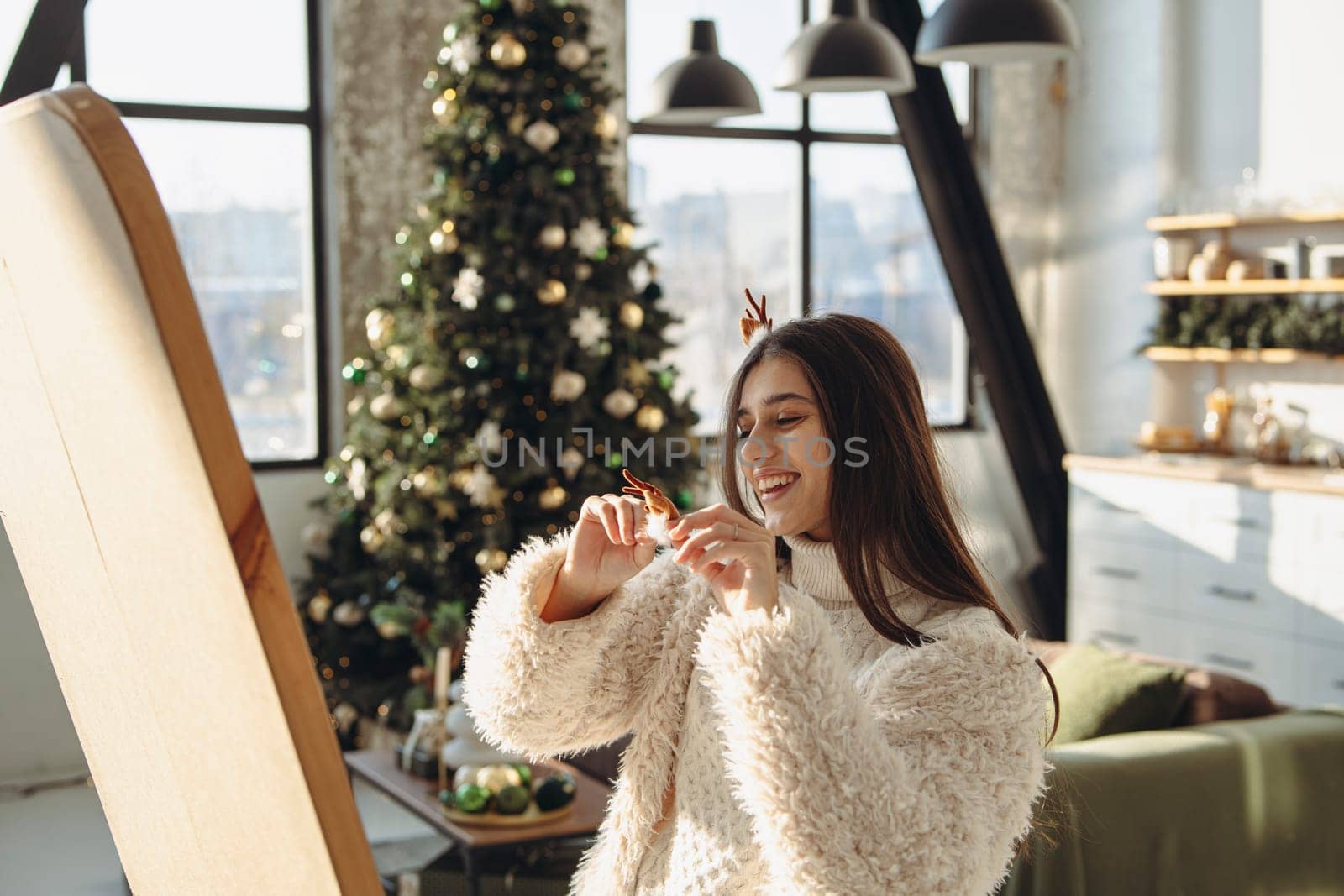With a merry spirit, a bright young woman wearing a Christmas reindeer mask lights up the apartment with her smile. High quality photo