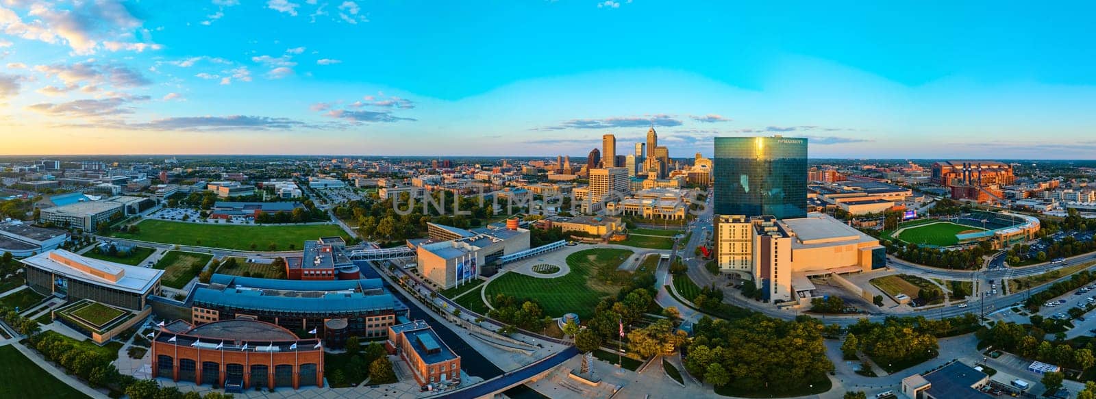 Golden Hour Panorama of Indianapolis Skyline, Showcasing Downtown Commercial Buildings, Educational Campus, and Sports Complex, Captured via DJI Mavic 3 Drone