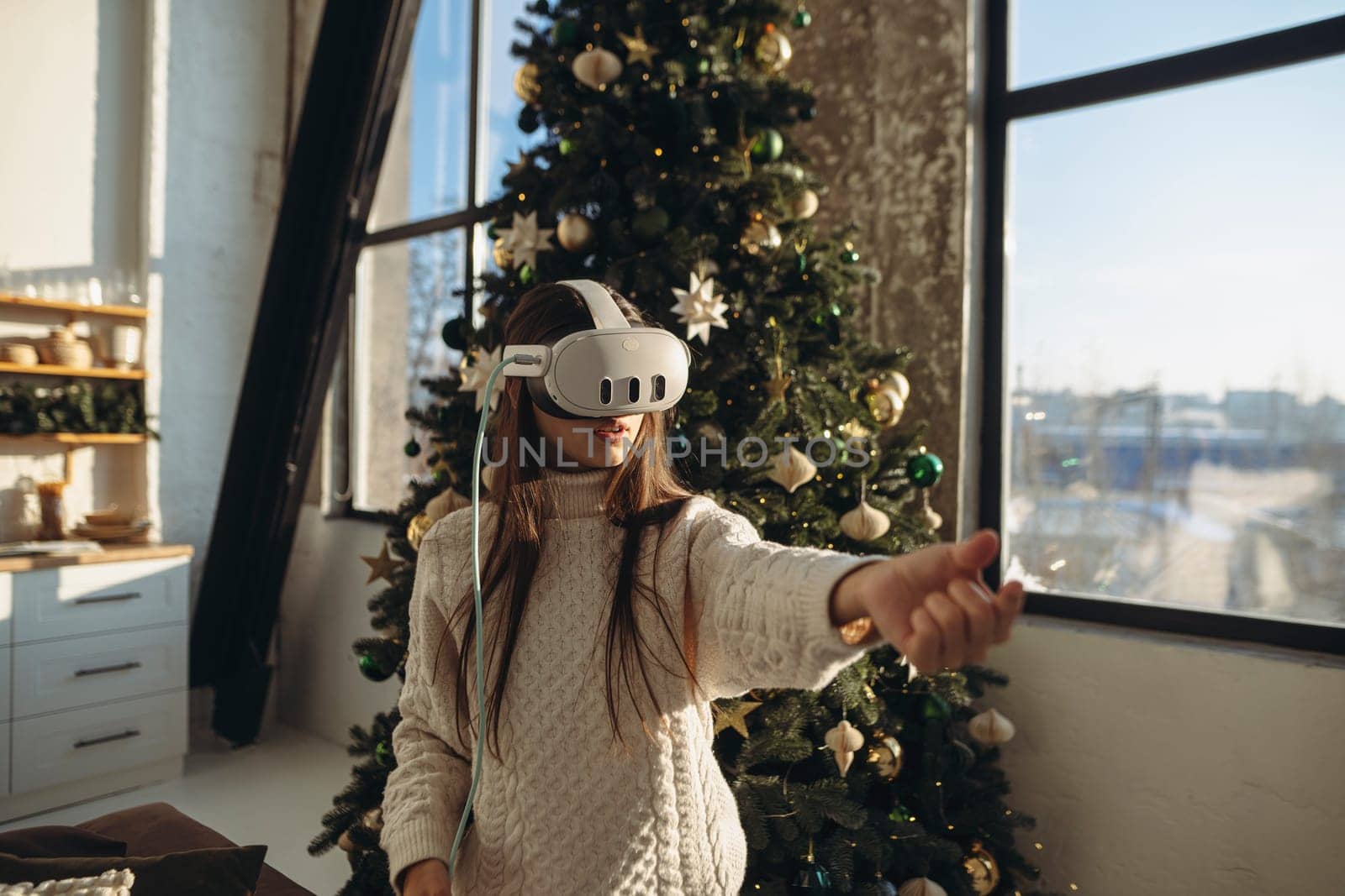 The portrait features a beautiful girl immersed in virtual reality, set against a Christmas tree. High quality photo