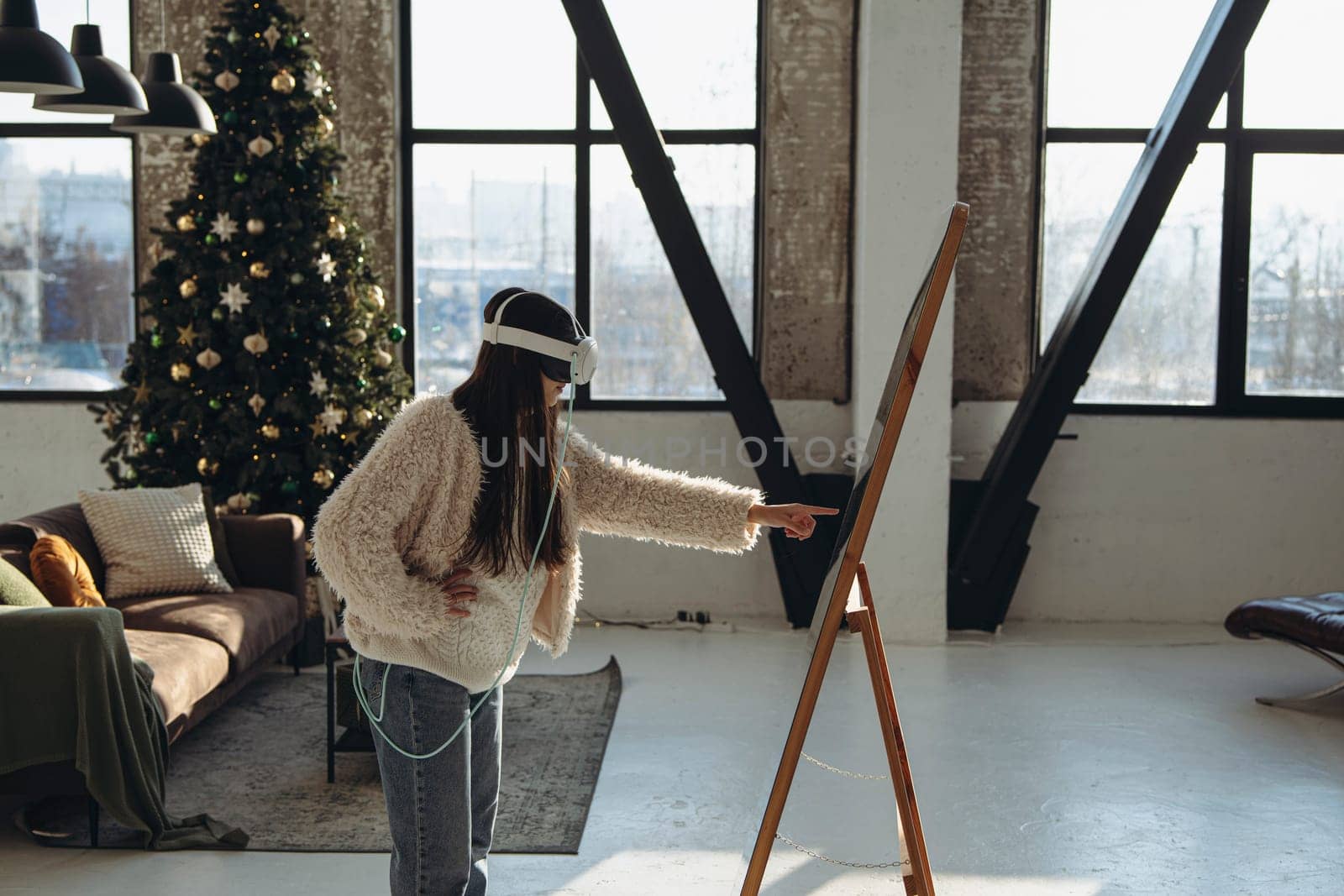 Amidst the Christmas aura, a young lady in light clothing and a virtual reality headset stands before the mirror. High quality photo