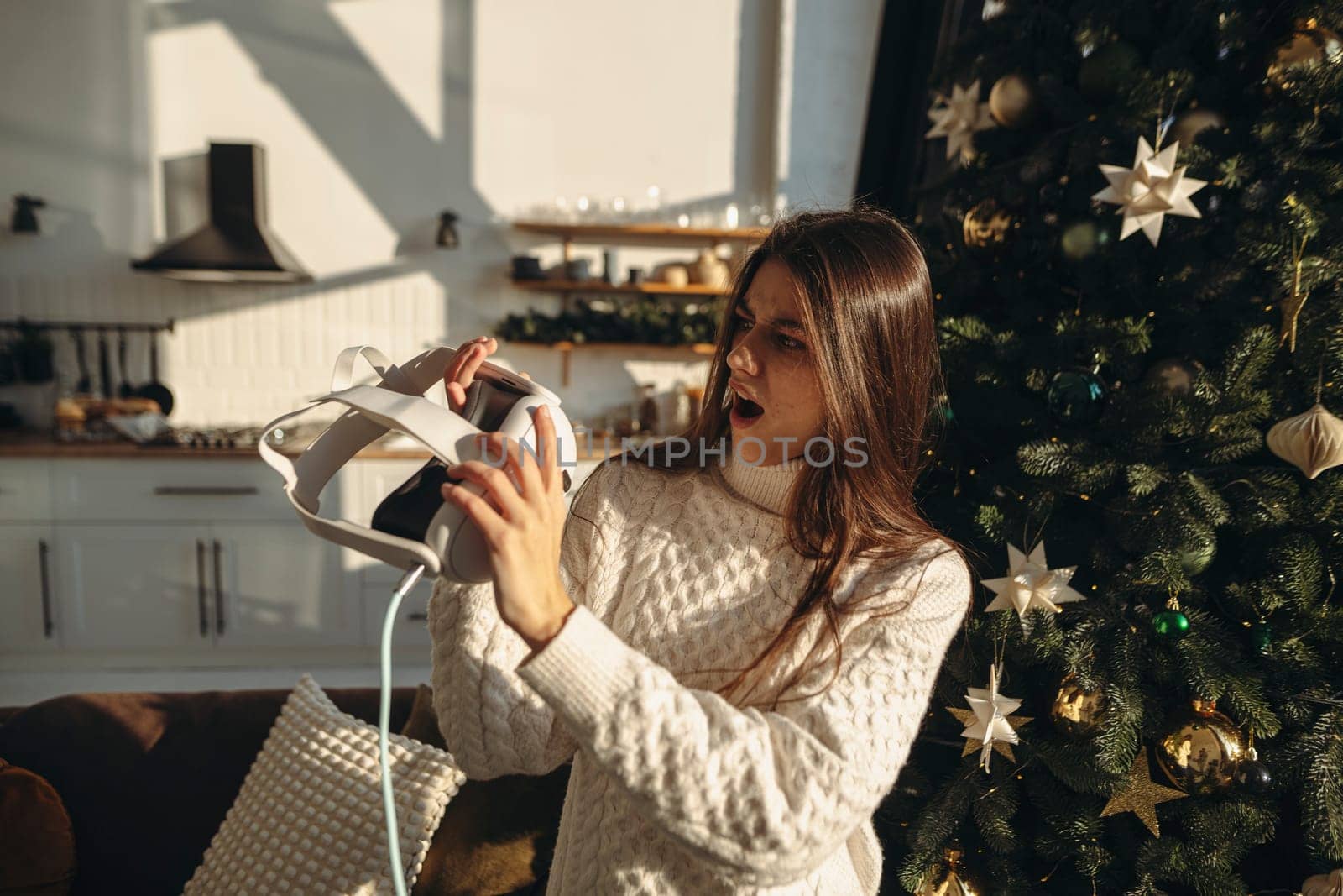 A spirited young woman unwrapped a virtual reality headset as a Christmas present. High quality photo