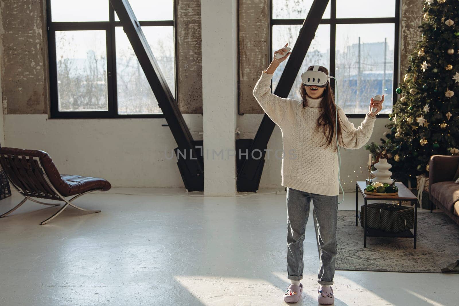 In the brightness of her apartment, a lively young woman wears a virtual reality headset. High quality photo