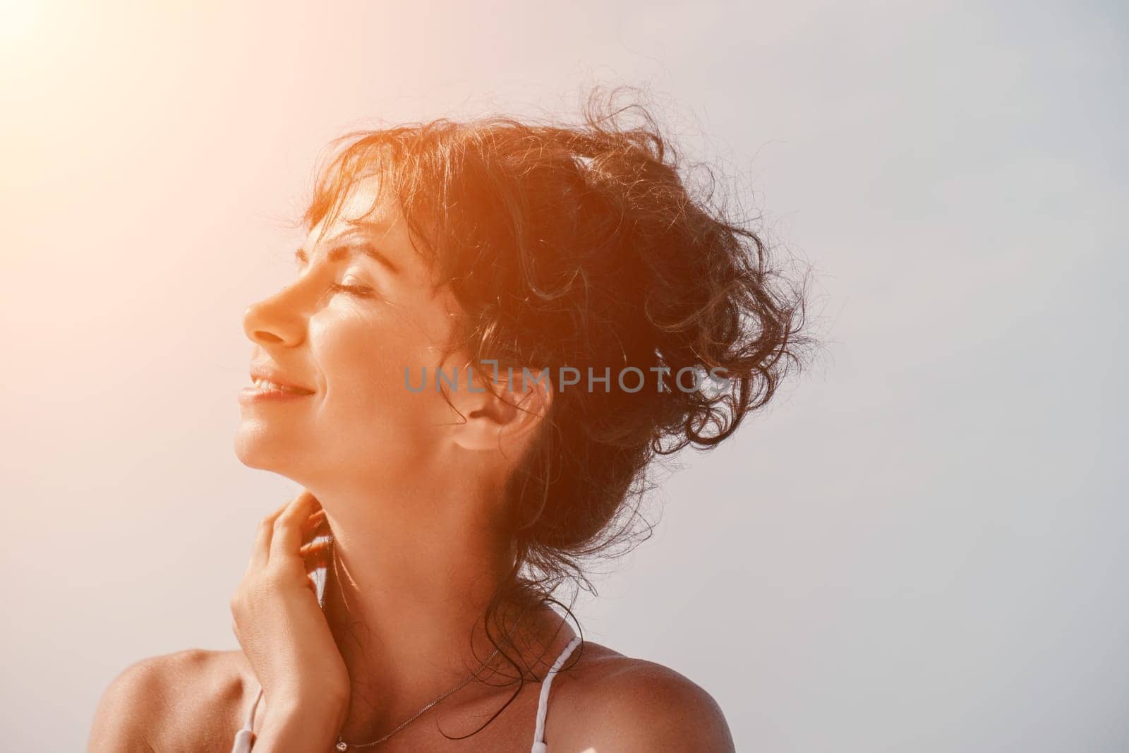 Woman travel sea. Young Happy woman in a long red dress posing on a beach near the sea on background of volcanic rocks, like in Iceland, sharing travel adventure journey