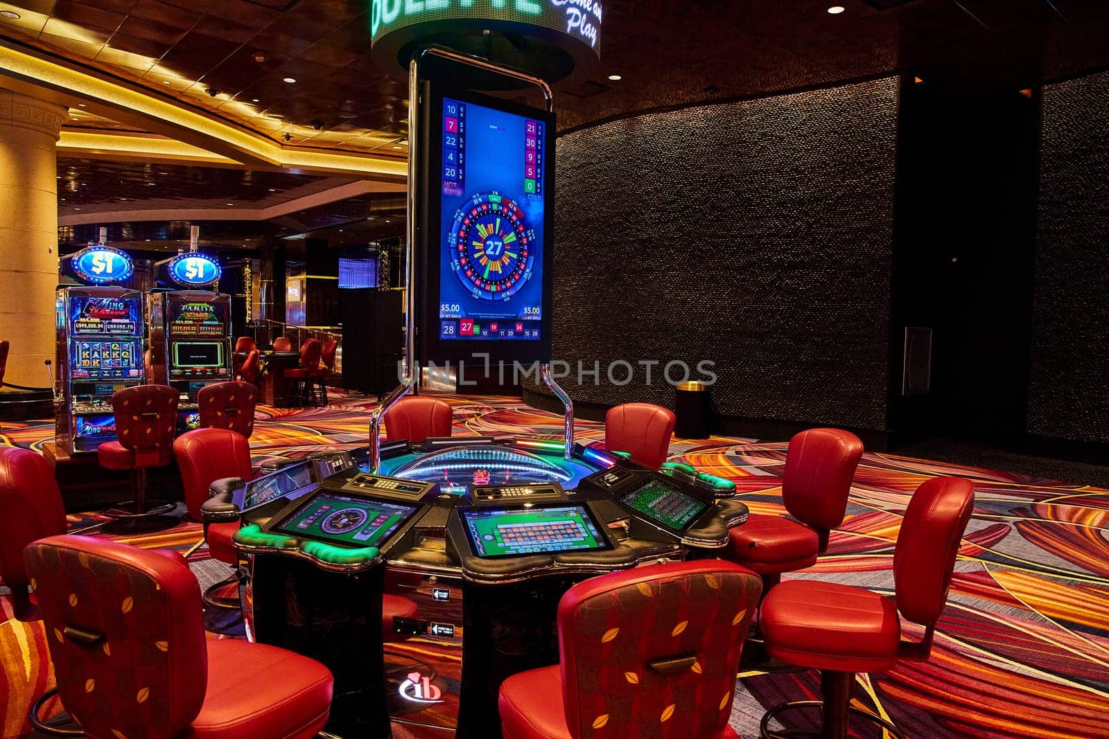 Vibrant electronic roulette table in a luxurious Bahamas casino, showcasing a lively gaming floor with bright slot machines