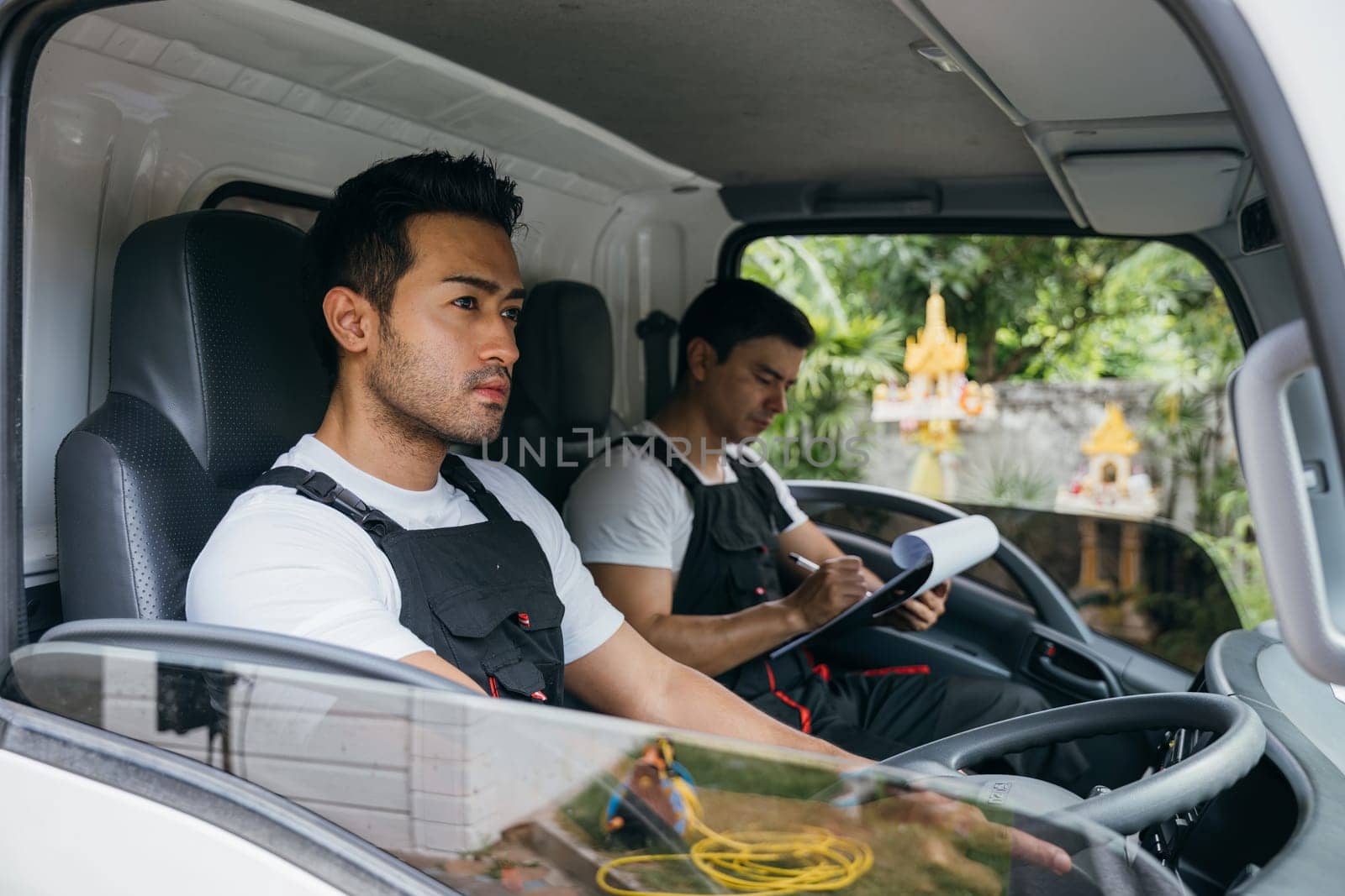 Transporting furniture, Mover workers driving truck for relocation service. Ethnicity diversity in the team. Smiling men delivering and unloading confidently. House moving service concept. by Sorapop